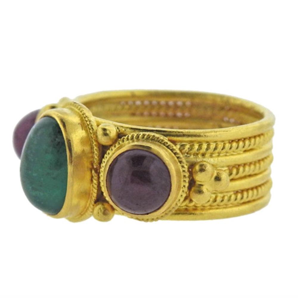Timeless 22 karat yellow gold band  crafted by Greek designer Ilias Lalaounis. The ring is set with cabochon emerald and ruby gemstones. The ring is currently size  6.5, and the ring top is 11mm wide. Signed: A.8, 750, Greece, Maker's hallmark.



