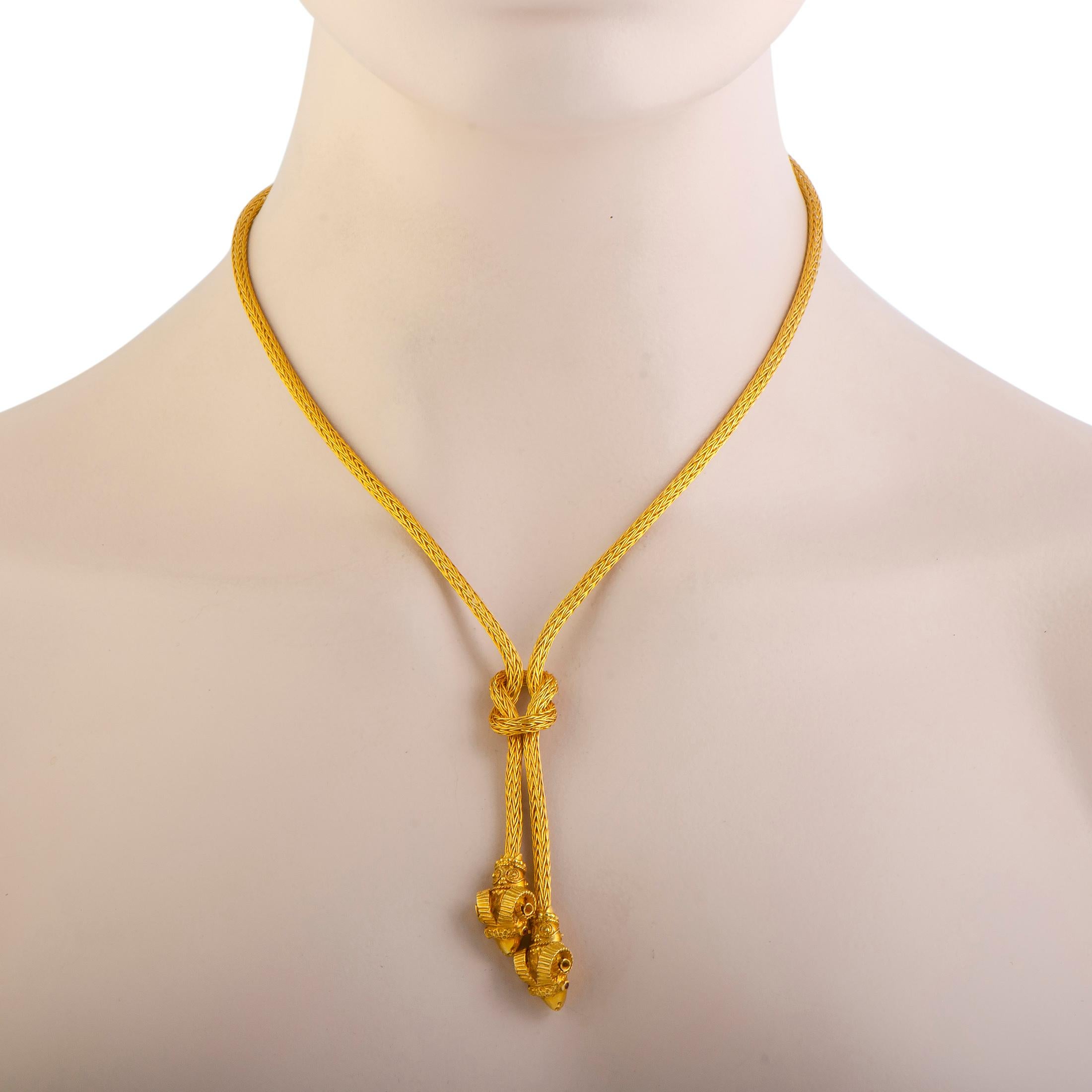 This utterly stunning Hercules knot necklace by Lalaounis is uniquely crafted in the beautiful shimmer of 18K yellow gold. The spectacular design includes double ram heads and is adorned with gorgeous rubies that give the necklace an extravagantly