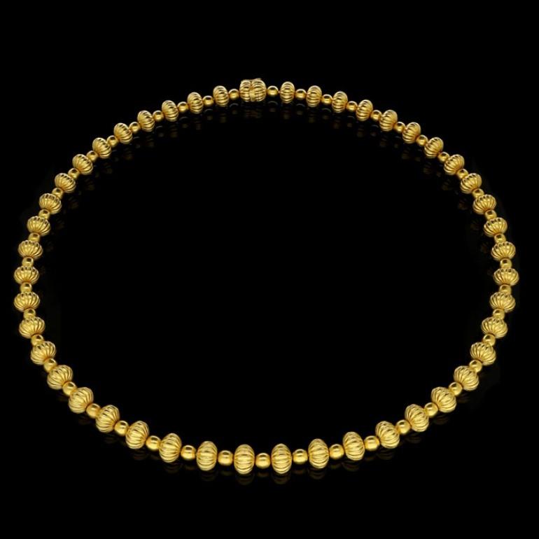 18ct yellow gold with maker's marks and signature
29.5” / 75cm long
133 grams

A stylish gold bead necklace by Lalaounis, c.1970s, from the 'Minoan and Mycenaean' collection, the necklace designed as a continuous row of fluted beads alternating with
