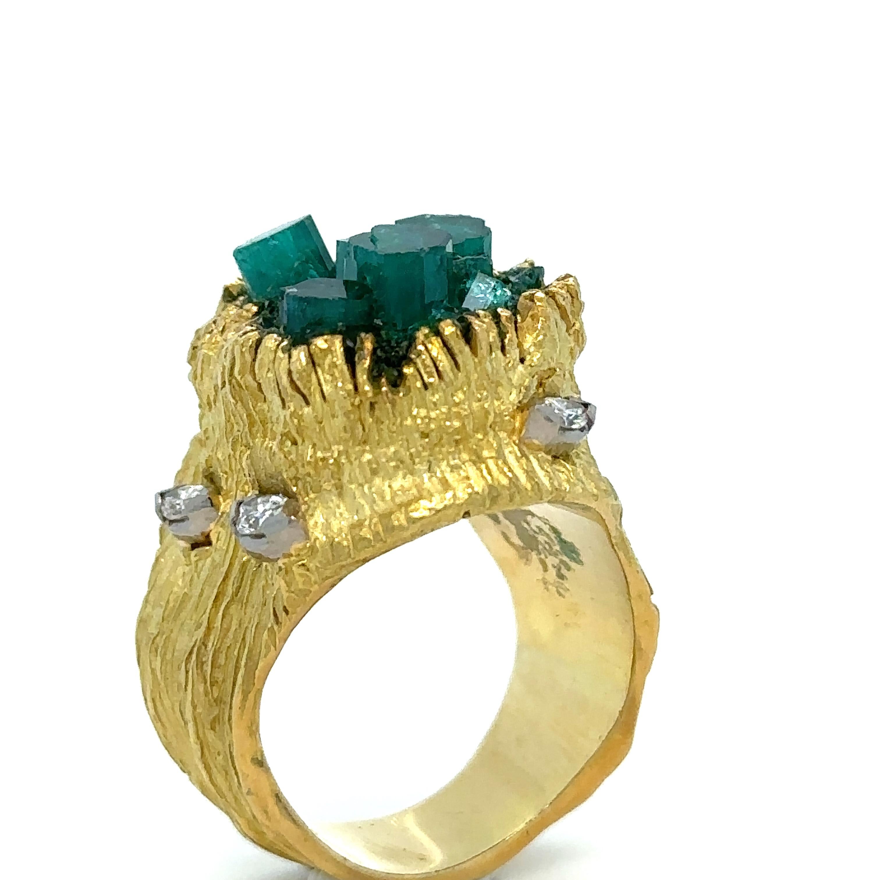 Unique features: 

Set to the top with emerald crystals in an organically modelled textured gold setting accented with five half collet-set marquise-cut diamonds, the diamonds together weighing approximately [0.15] carat, gross weight 24 grams.