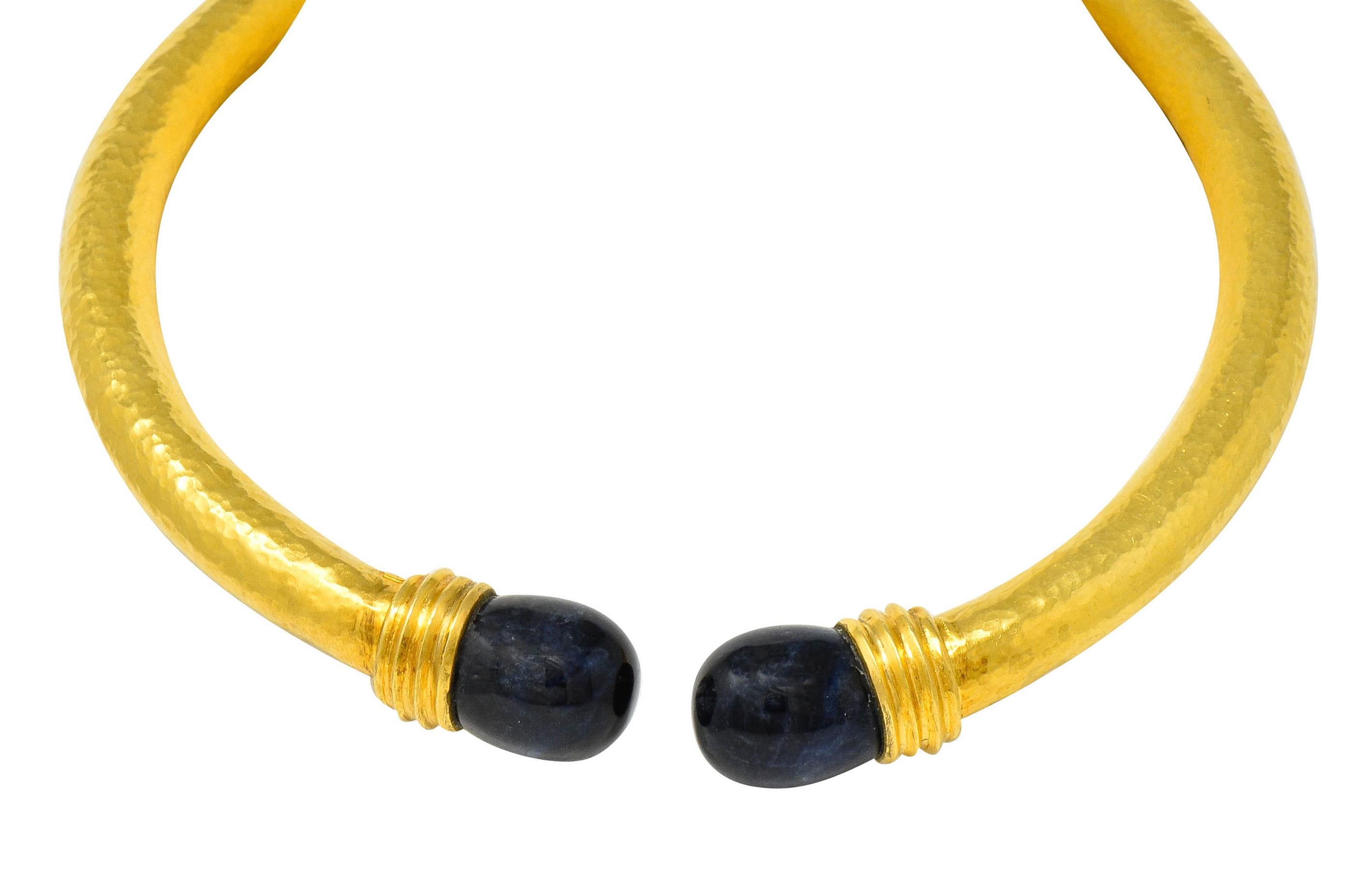 Collar necklace that opens via concealed spring hinge and is with a strongly hammered finish

With two polished sodalite terminals at front measuring approximately 11/16 x 5/8 inch

Opaque with swirled strongly dark blue to blue color and exhibits