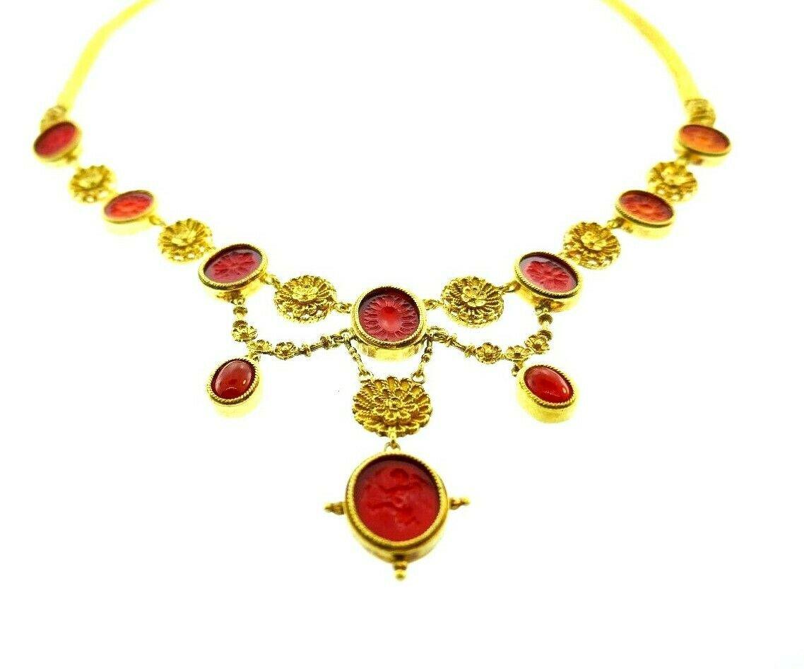Beautiful 18k yellow gold and carnelian necklace by Ilias Lalaounis. Carved carnelian and filigreed elements are hanging on a braided yellow gold chain. Features box clasp with floral design. Stamped with Lalaounis maker's mark, a hallmark for 18k