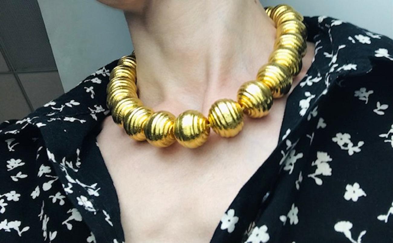 A magnificent 18k gold necklace by Ilias Lalaounis. The piece is crafted of the textured gold spheres strung on a woven gold thread. The texture of the gold makes the beads softly shimmer and creates a beautiful effect of fluidity. This minimalistic