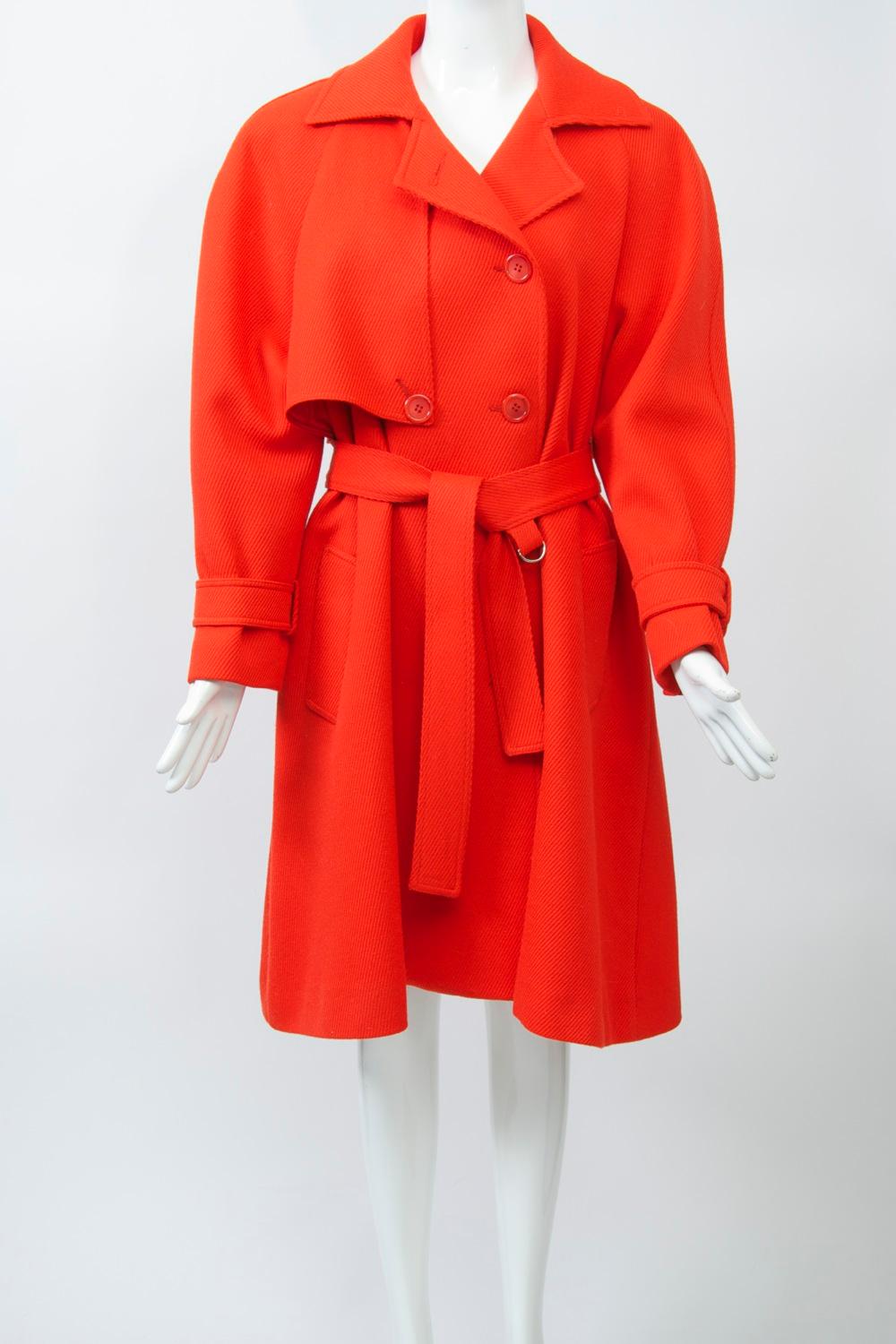 Ilie Wacs was a gifted New York designer of coats and suits, both under his eponymous label and for the highly regarded manufacturer Originala. This example of his later work, from the 1980s, is his adaptation of the trench coat in bright red wool