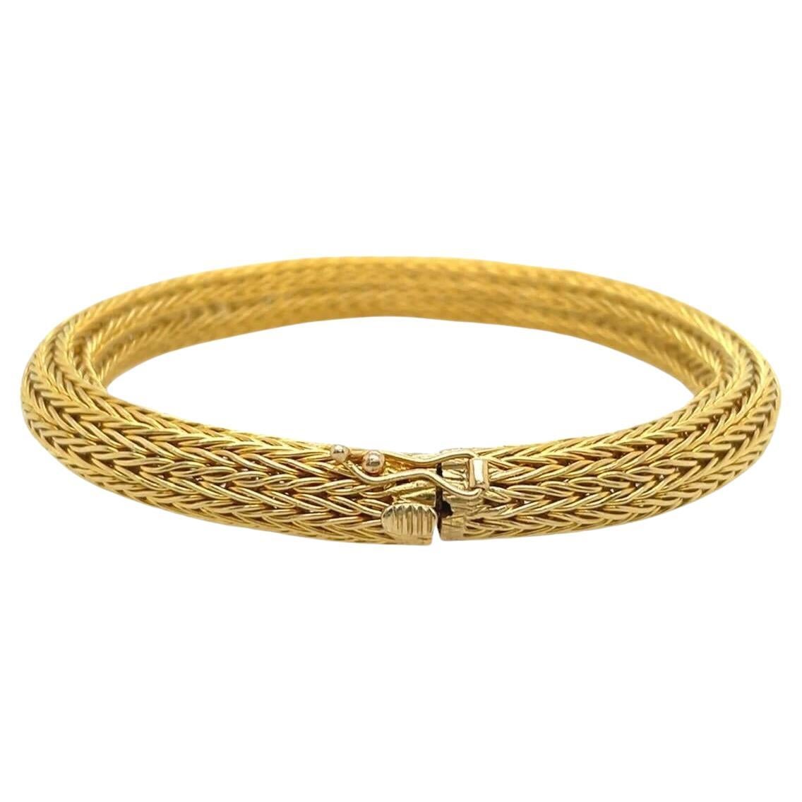 An 18 karat yellow gold bracelet, Ilias Lalaounis.  Designed as a cylindrical length of flexible mesh formed of wheat chains.  Length approximately 7 1/2 inches.  Gross weight approximately 37.70 grams.  Signed Ilias Lalaounis. 

 