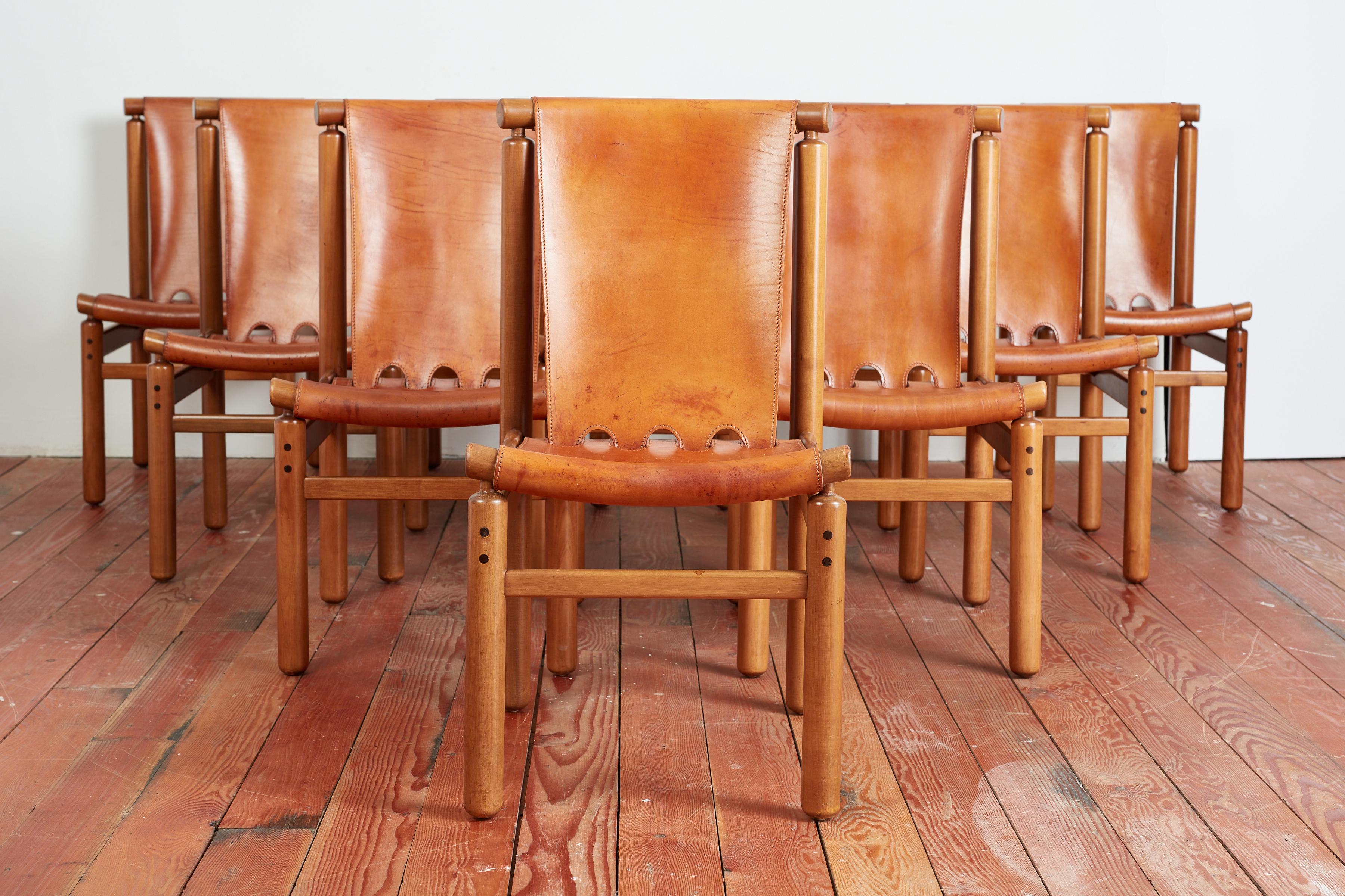 Incredible rare set of 10 leather Italian dining chairs by Ilmari Tapiovaara for La Permanente Mobili Cantù, circa 1950s.
Wonderful thick saddle leather with great patina'd leather on solid beech wood frames with cylinder shape. 
Cognac leather has
