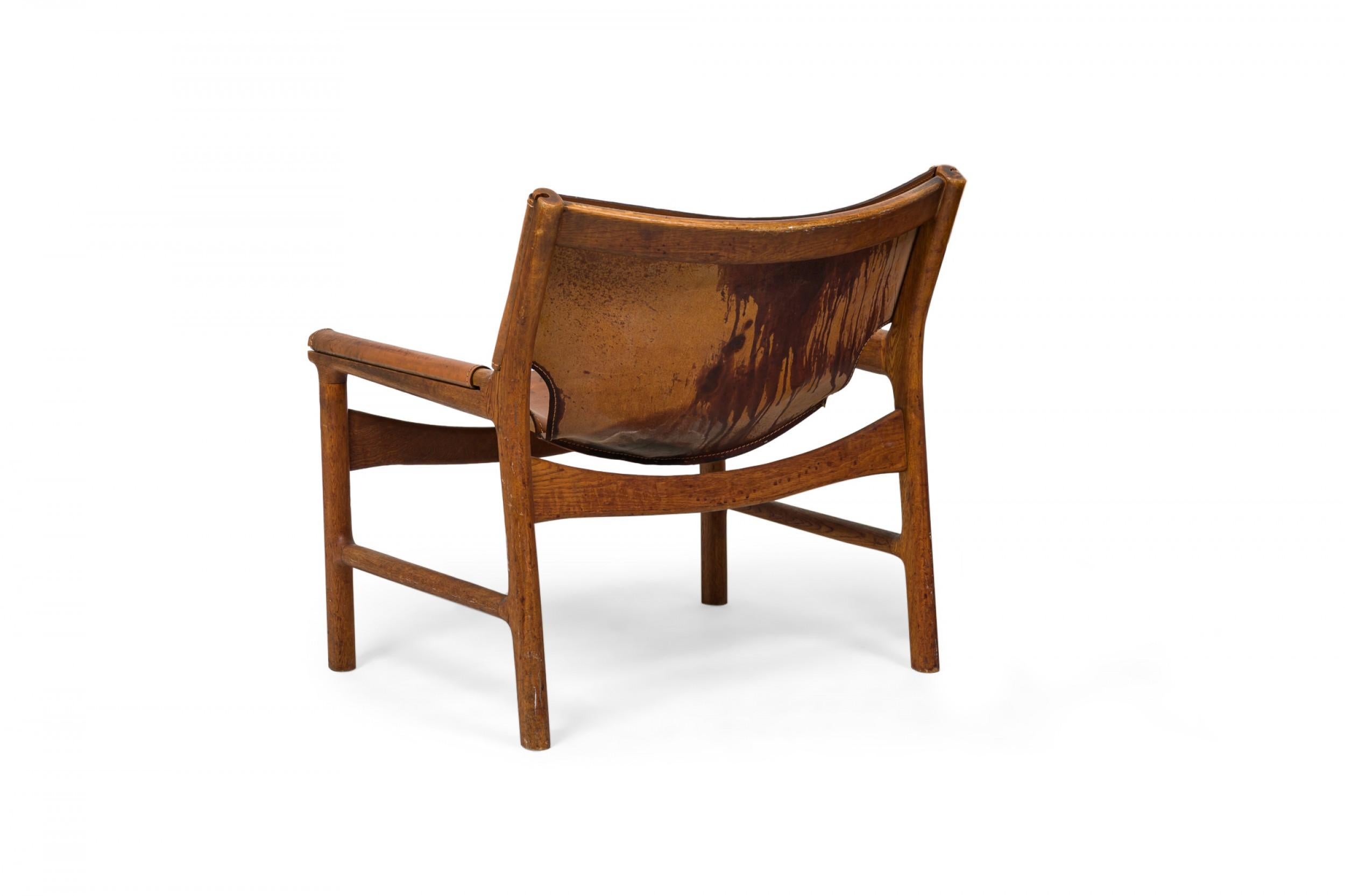 Scandinavo moderno Illum Wikkelsø è una sedia da salotto danese in pelle caramello e legno di quercia dal design a fionda in vendita
