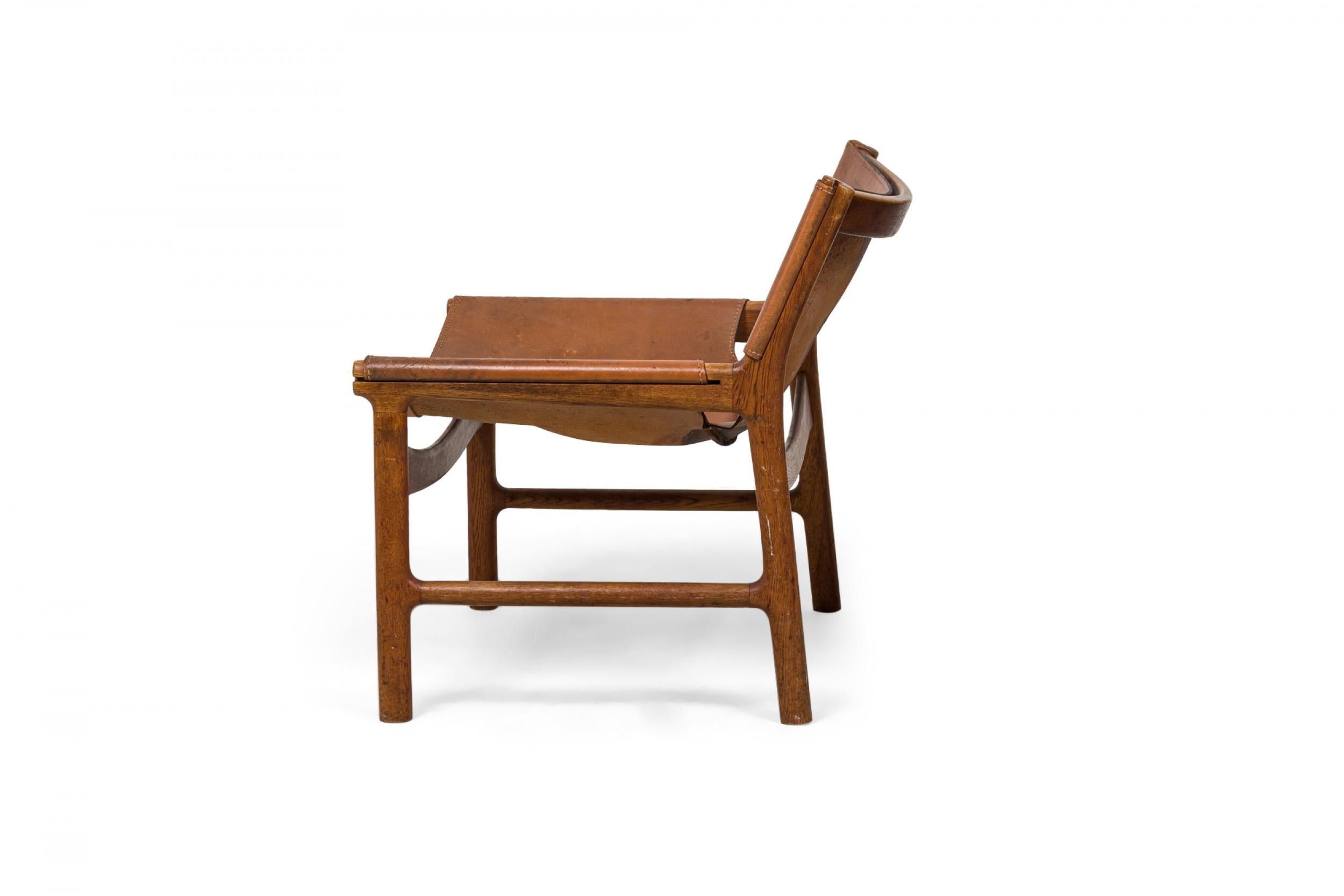 Danese Illum Wikkelsø è una sedia da salotto danese in pelle caramello e legno di quercia dal design a fionda in vendita