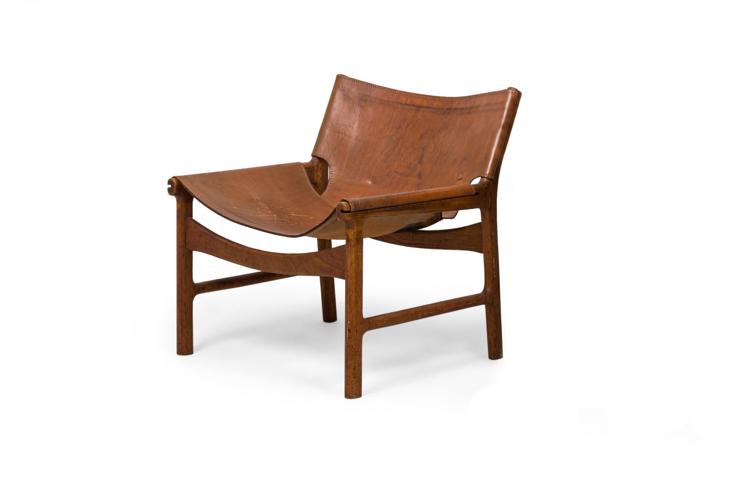 Fatto a mano Illum Wikkelsø è una sedia da salotto danese in pelle caramello e legno di quercia dal design a fionda in vendita