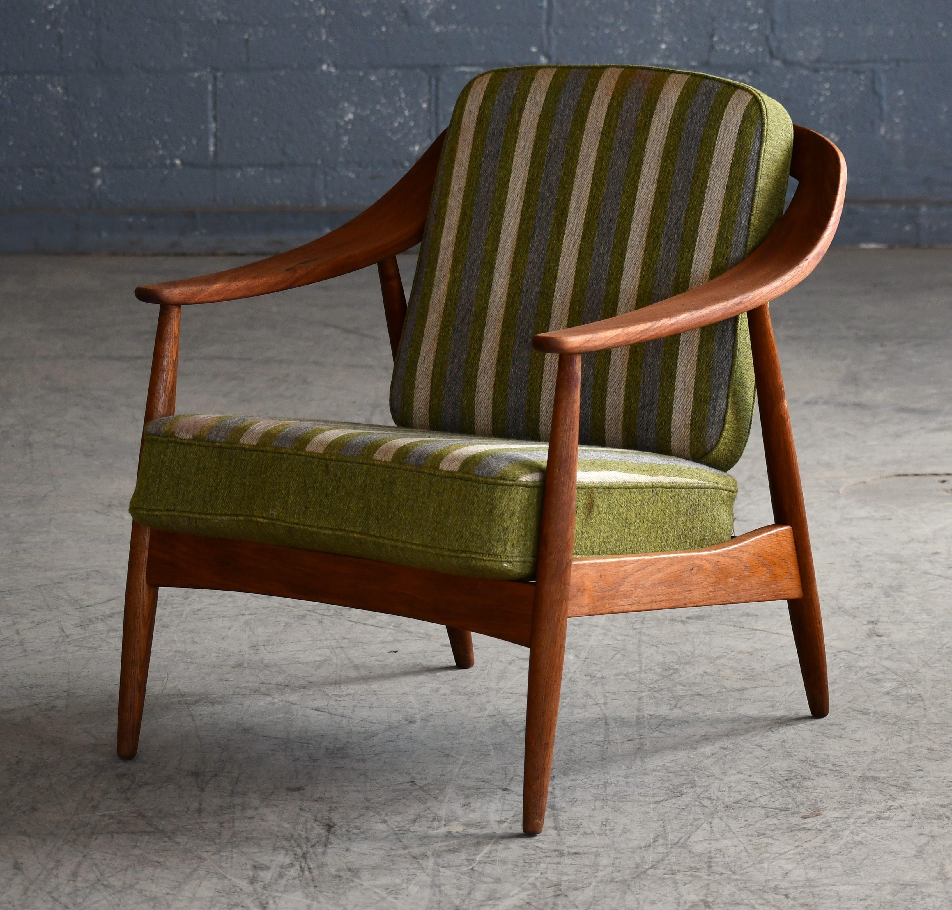 Classic and rare easy chair in oak and teak for Soren Willladsen from the 1950's. Curved armrests in teak sweeping around the sides and back of the chair. Legs and frame made from solid oak that has obtained a nice color and patina matching the teak