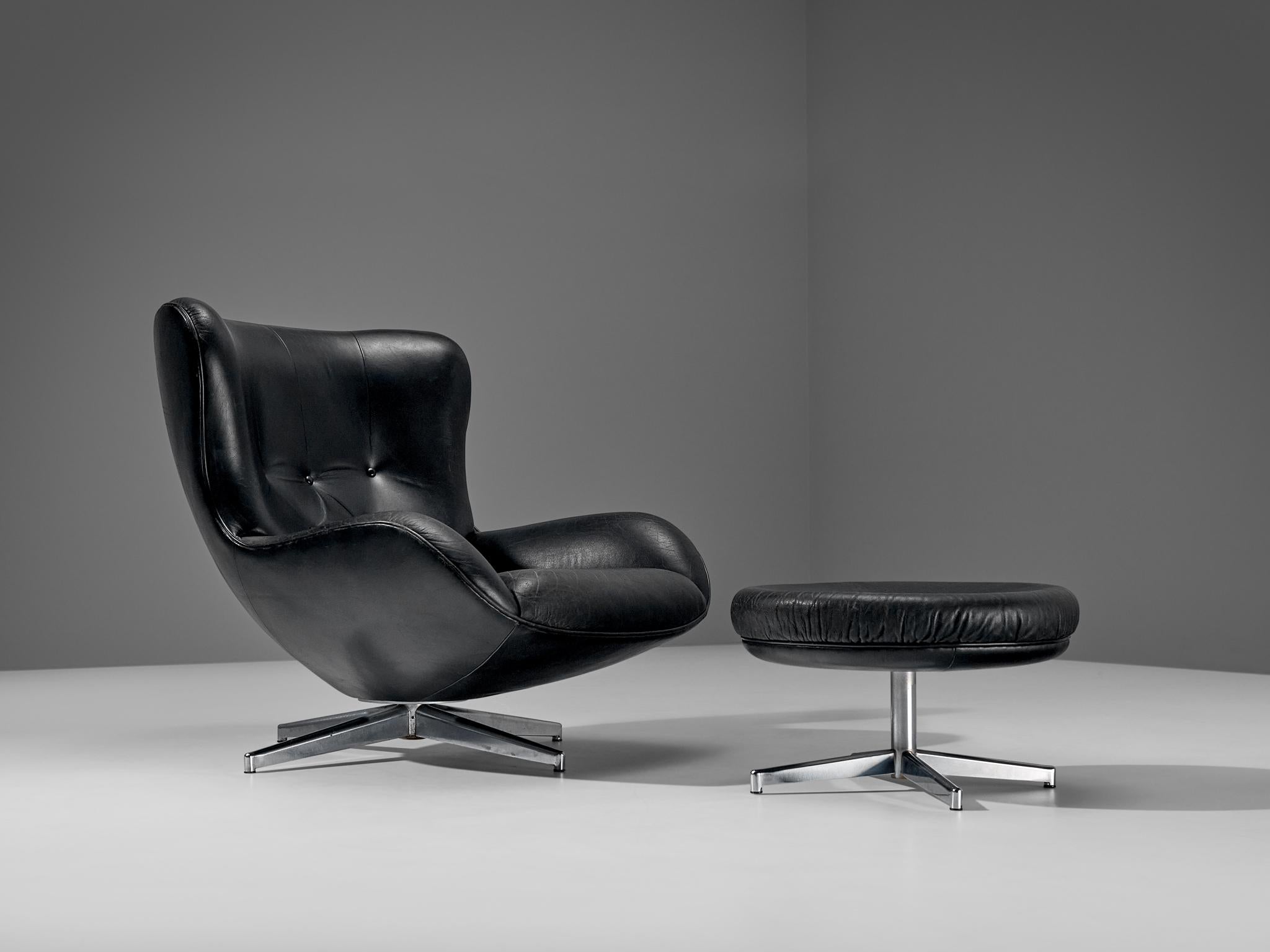 Illum Wikkelsø for A. Mikael Laursen, swivel lounge chair with ottoman model ML214, black leather, metal, Denmark, 1960s

Organic shaped easy chair in patinated black leather by Danish designer Illum Wikkelsø. This swivel chair shows some nice