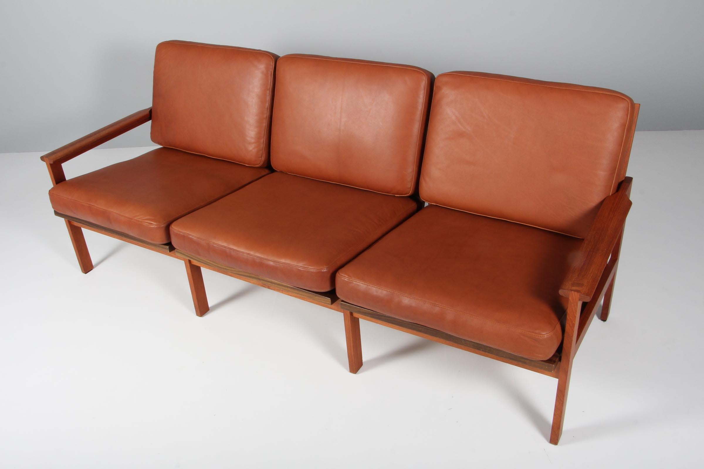 Illum Wikkelso for N. Eilersen three seat sofa in solid teak.

New upholstered with brandy coloured aniline leather. 

Model Capella, made by N. Eilersen.
 