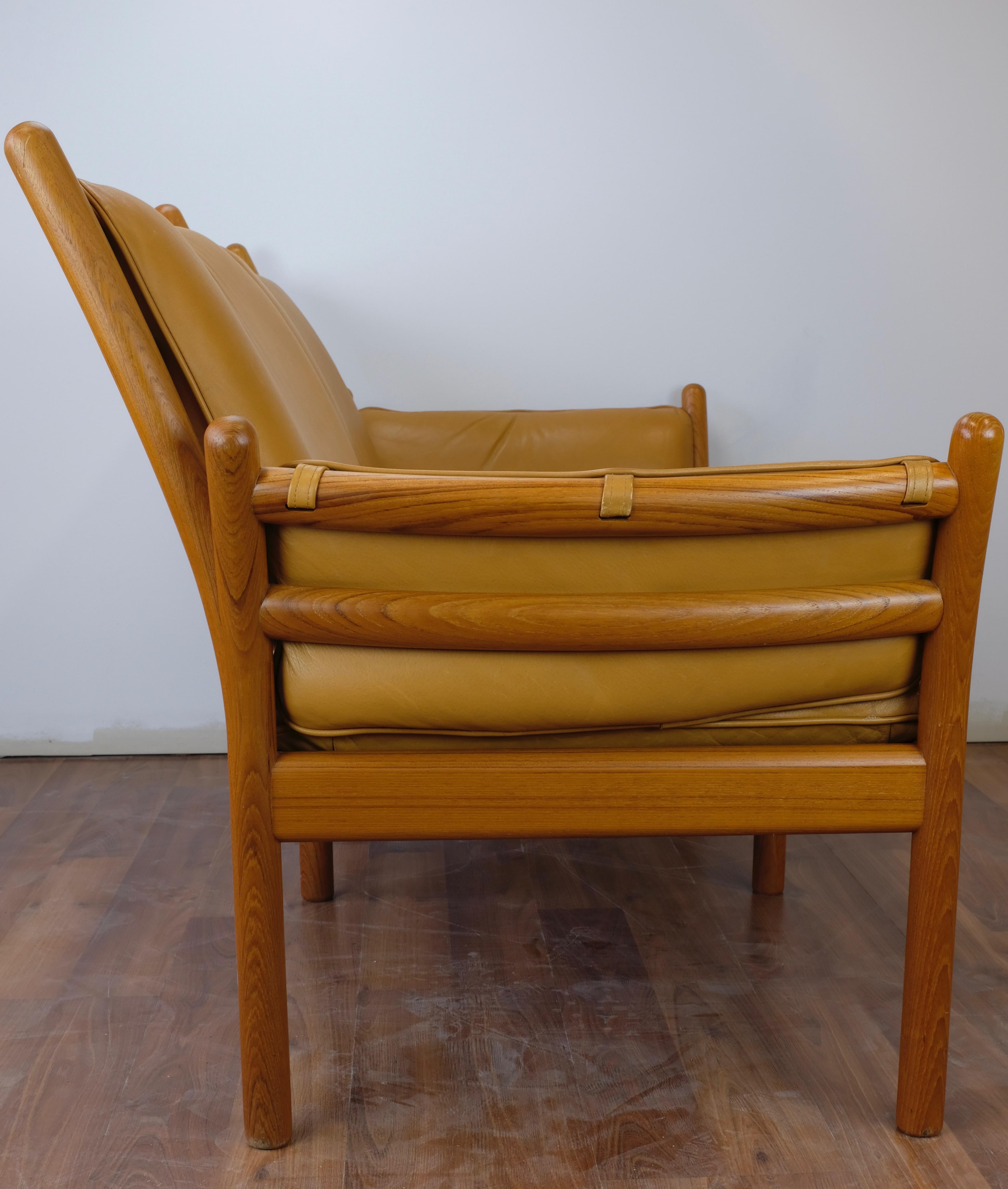 One 'Genius' loveseat designed by Illum Wikkelsø and made in Denmark by CF Christensen Silkeborg.

The frame is constructed of solid teak. Cognac leather seat cushions are loose while back and arm cushions are secured to the frame with straps and