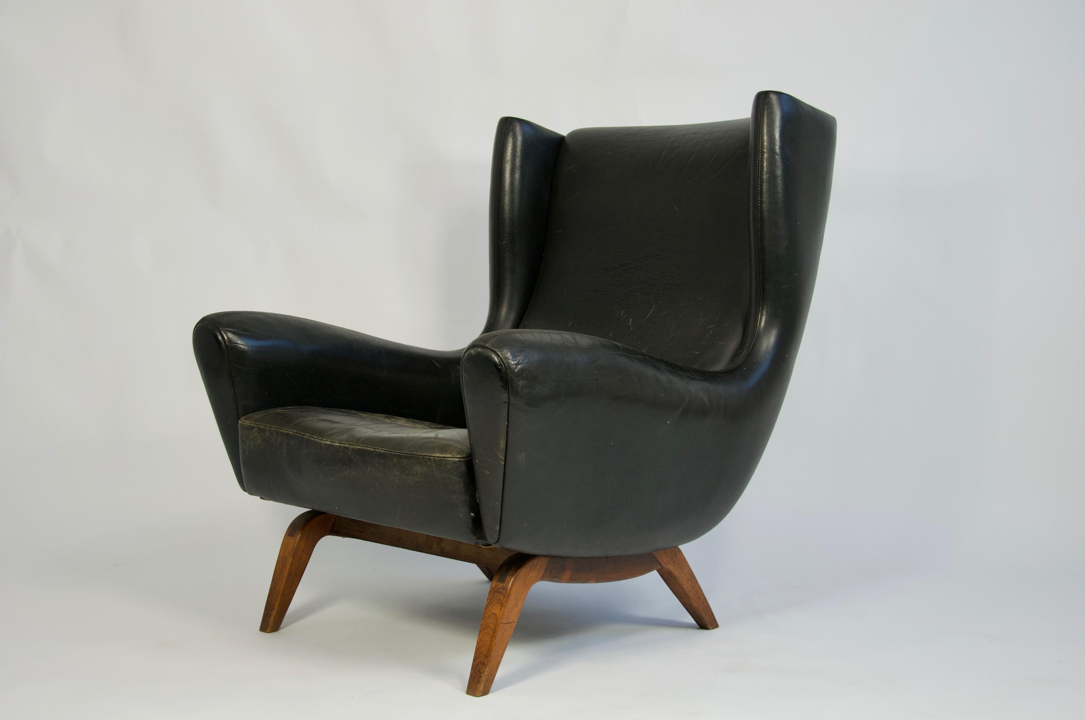 Offered by OLIVER MODERN, Illum Wikkelsø black leather lounge chair with rosewood base. Model 110 for Søren Willadsen, Denmark.