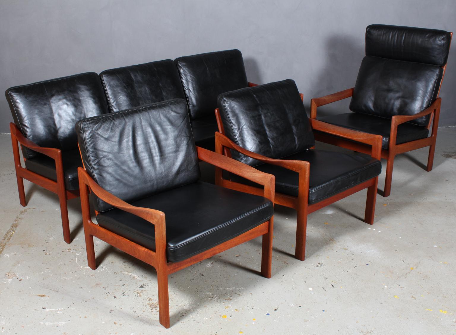 Illum Wikkelsø living room set consisting of three seater sofa, one highback chair  Cushions original upholstered with black patinated leather.

Frame of teak.

Model 20, made by N. Eilersen, 1960s.

Possible to buy seperate as well.

LOW BACK