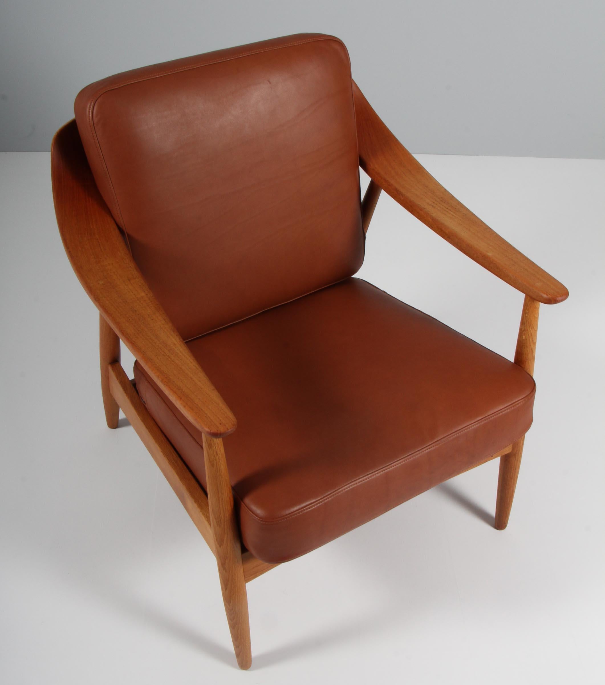 Illum Wikkelsø lounge chair in teak and oak.

New upholstered cushions in tan aniline leather.

Made by Søren Willadsen.