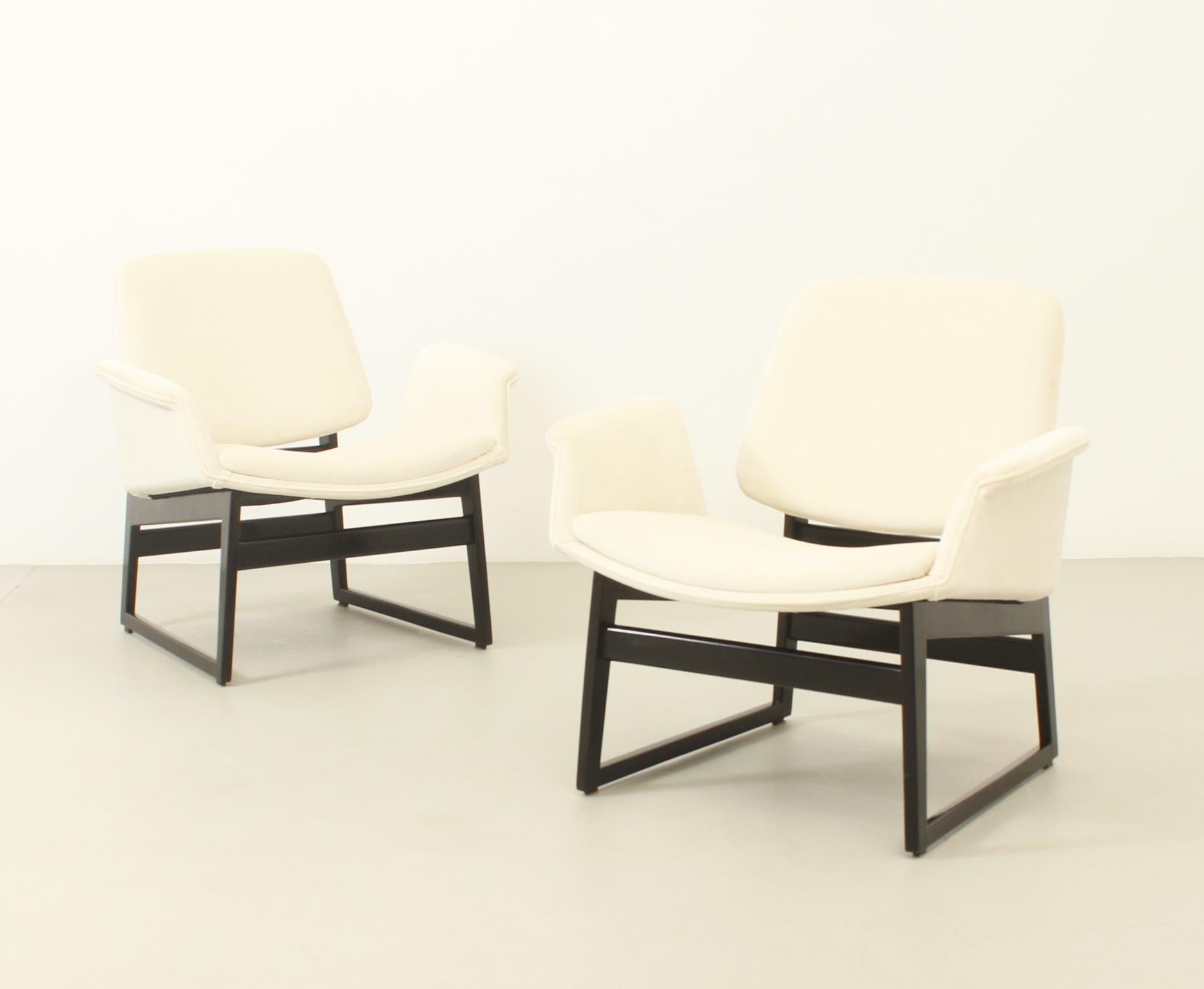 Pair of lounge chairs designed in 1960 by Illum Wikkelsø for Arflex, Italy. Wikkelsø's model 451 redesign in 1960 for Arflex, Italy with metal or wood base. This pair are with a black lacquered wooden base and new off-white velvet upholstery. 