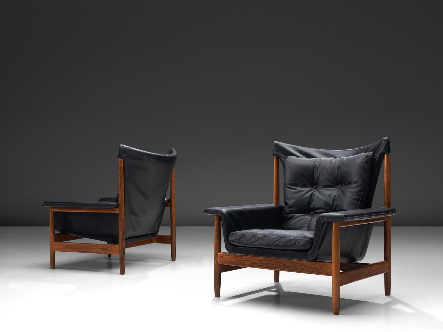 Illum Wikkelsø, pair of lounge chairs, black leather and rosewood, Denmark, 1960s.

This set of lounge chairs feature a rosewood, geometric frame. The back seat is hanging from the upper part of the frame. Also the seat is leaning on the frame, The