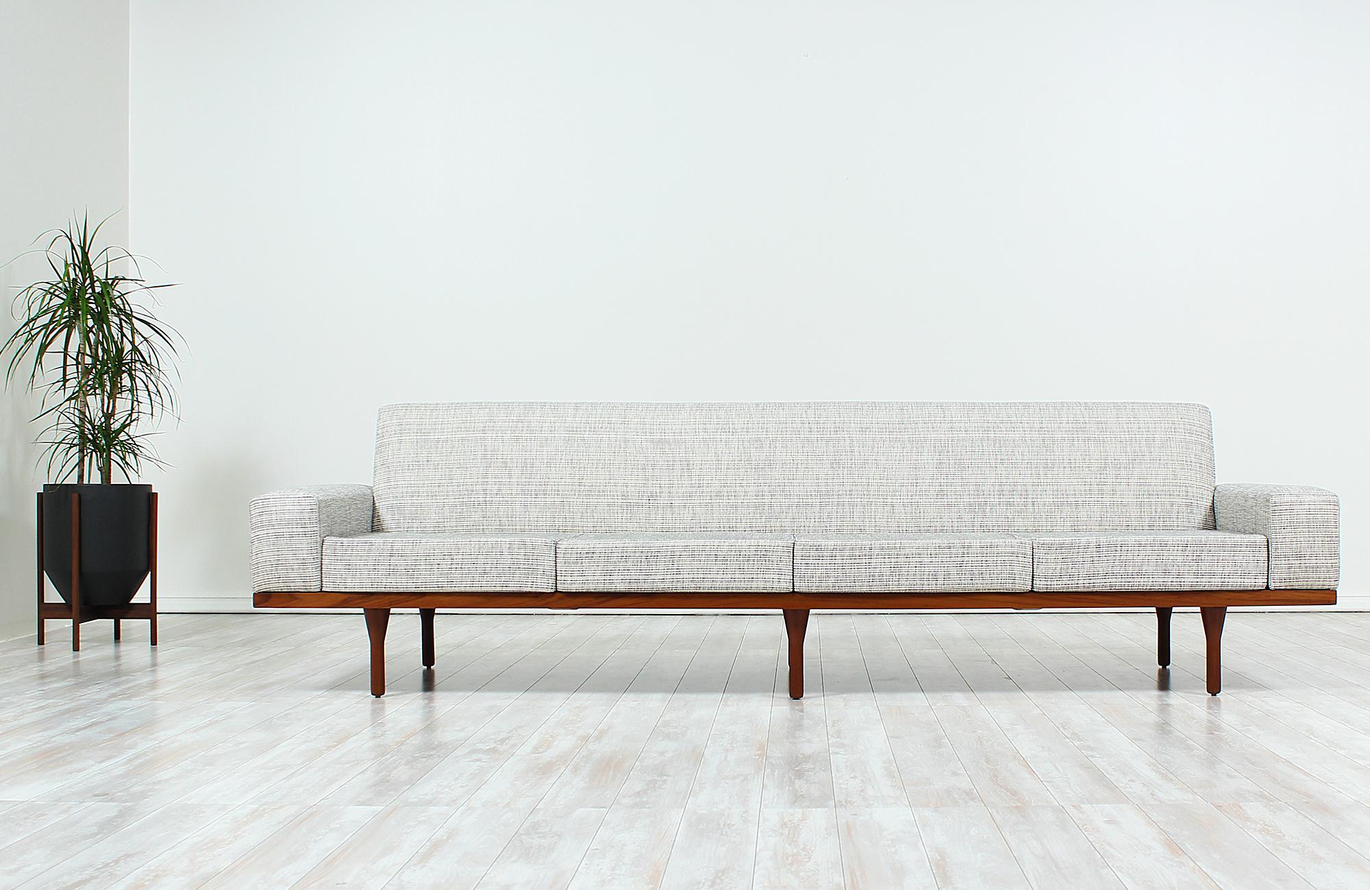 Exceptional Model 50-4 sofa designed by Illum Wikkelsø and manufactured in Denmark by Soren Willadsen, circa 1960s. This large Danish modern design features a solid teak frame exposing warm, grainy details that contrast beautifully with the new