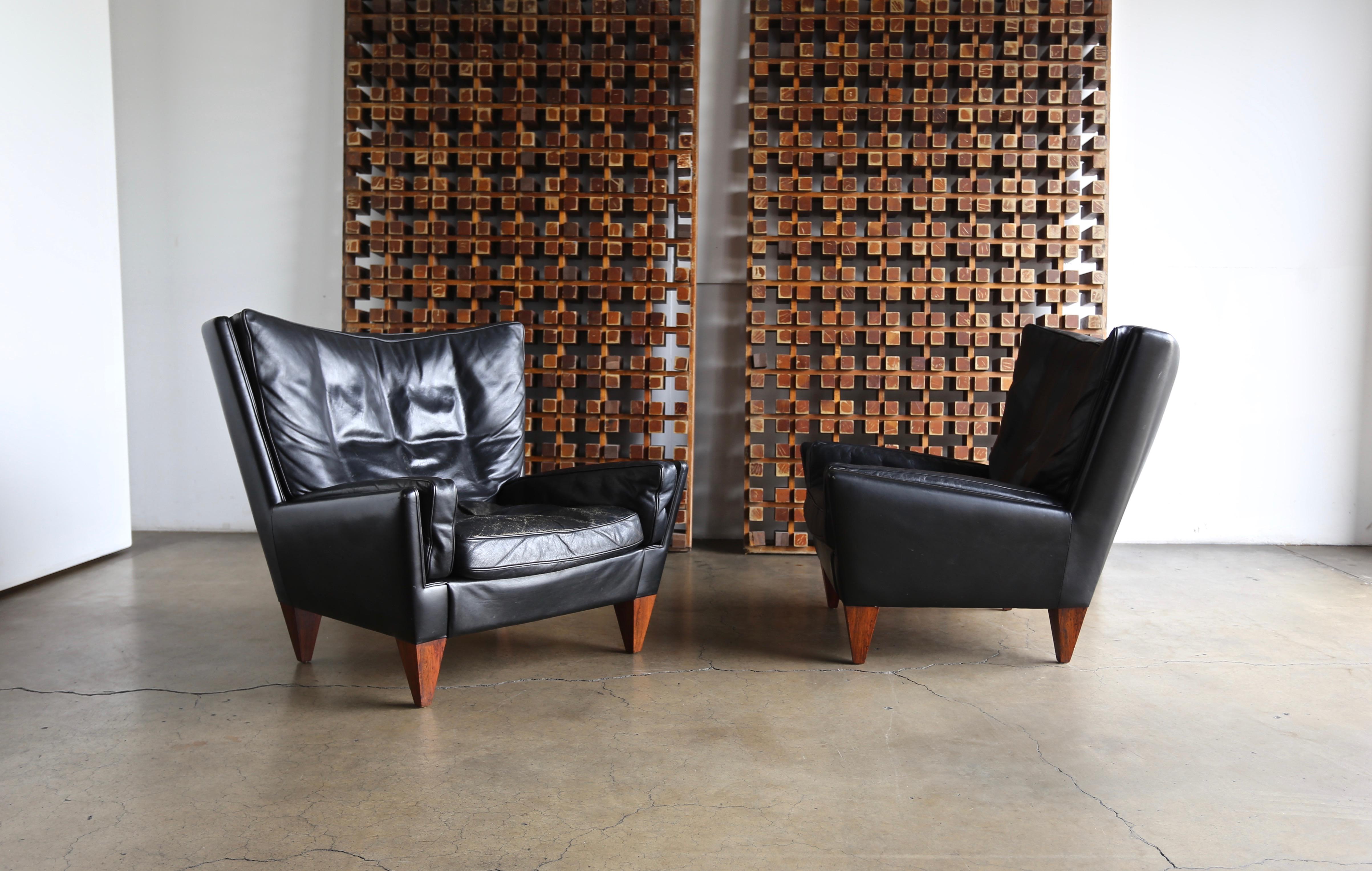 Illum Wikkelsø black leather pyramid chairs for Holger Christiansen circa 1965. Beautiful patina to the original leather and rosewood.