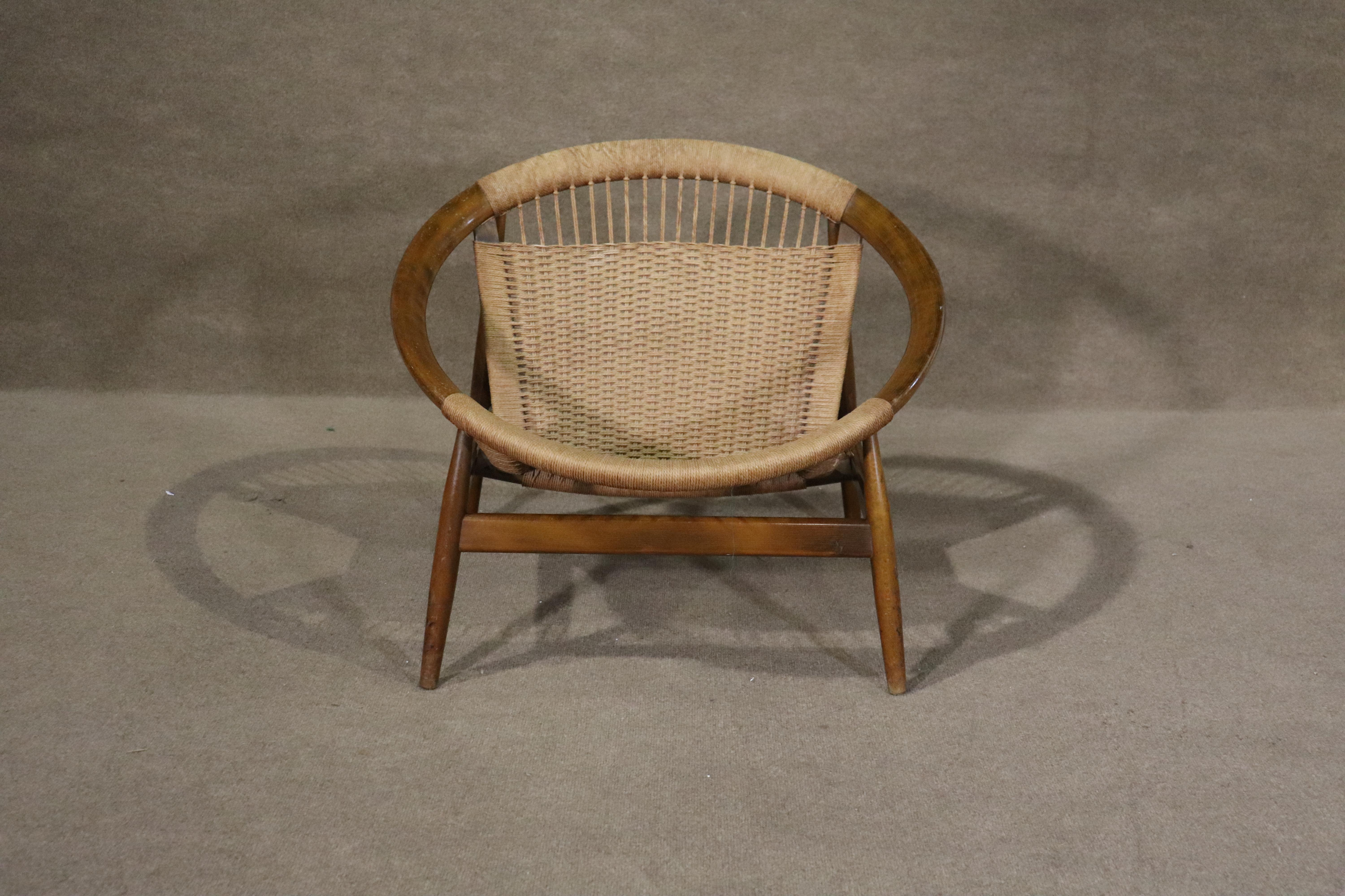This iconic mid-century modern hoop chair, designed by Illum Wikkelsø, features a round walnut frame with woven rope seating. Comfortable for indoor and outdoor settings.
Please confirm location NY or NJ