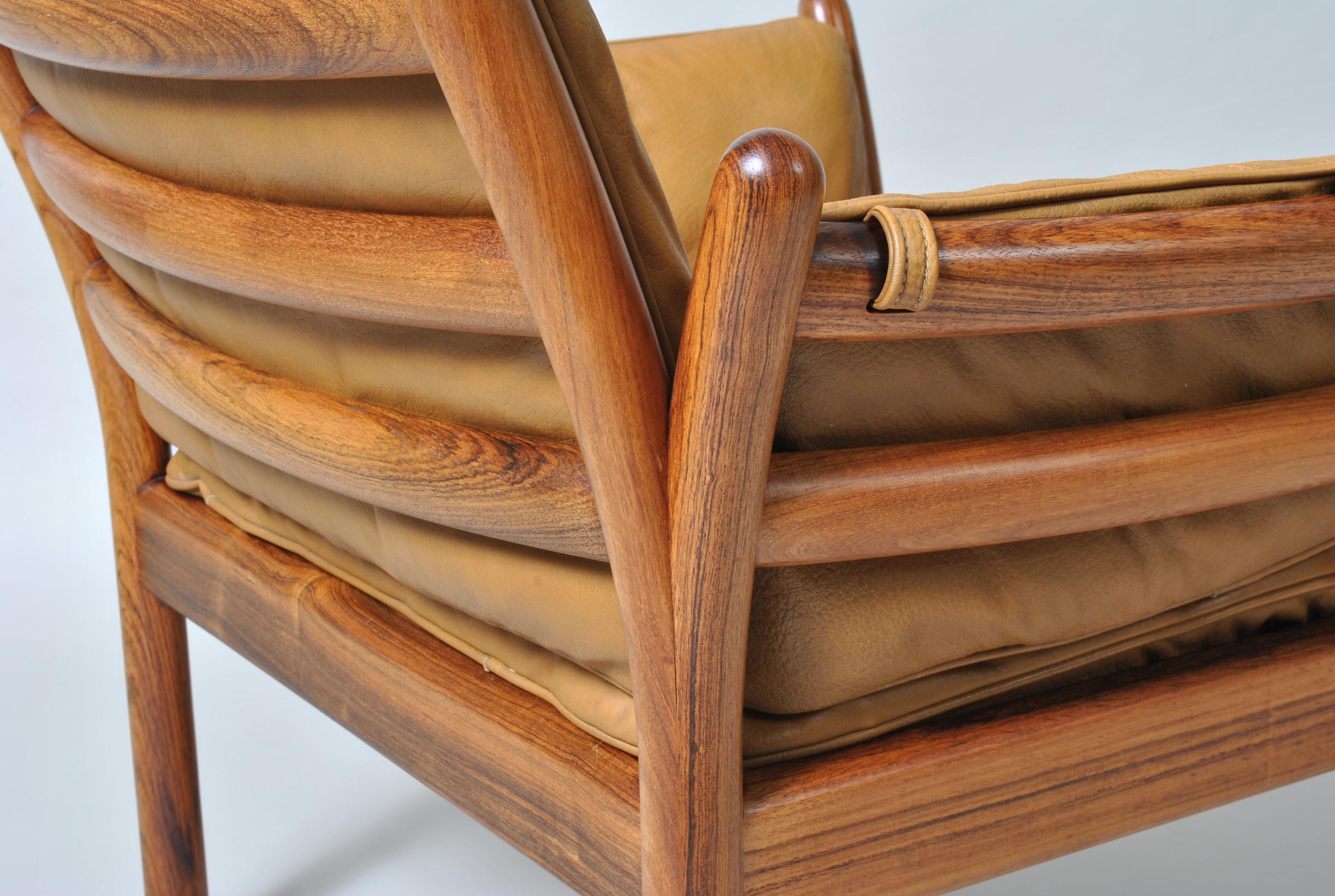 Classic ‘Genius’ lounge chair by Illum Wikkelsø for CFC Silkeborg. Produced by CFC in Denmark, circa 1950s.
Solid rosewood caged frame with tan leather cushions. Fine quality craftsmanship.
Extremely comfortable. A wonderful design by Illum