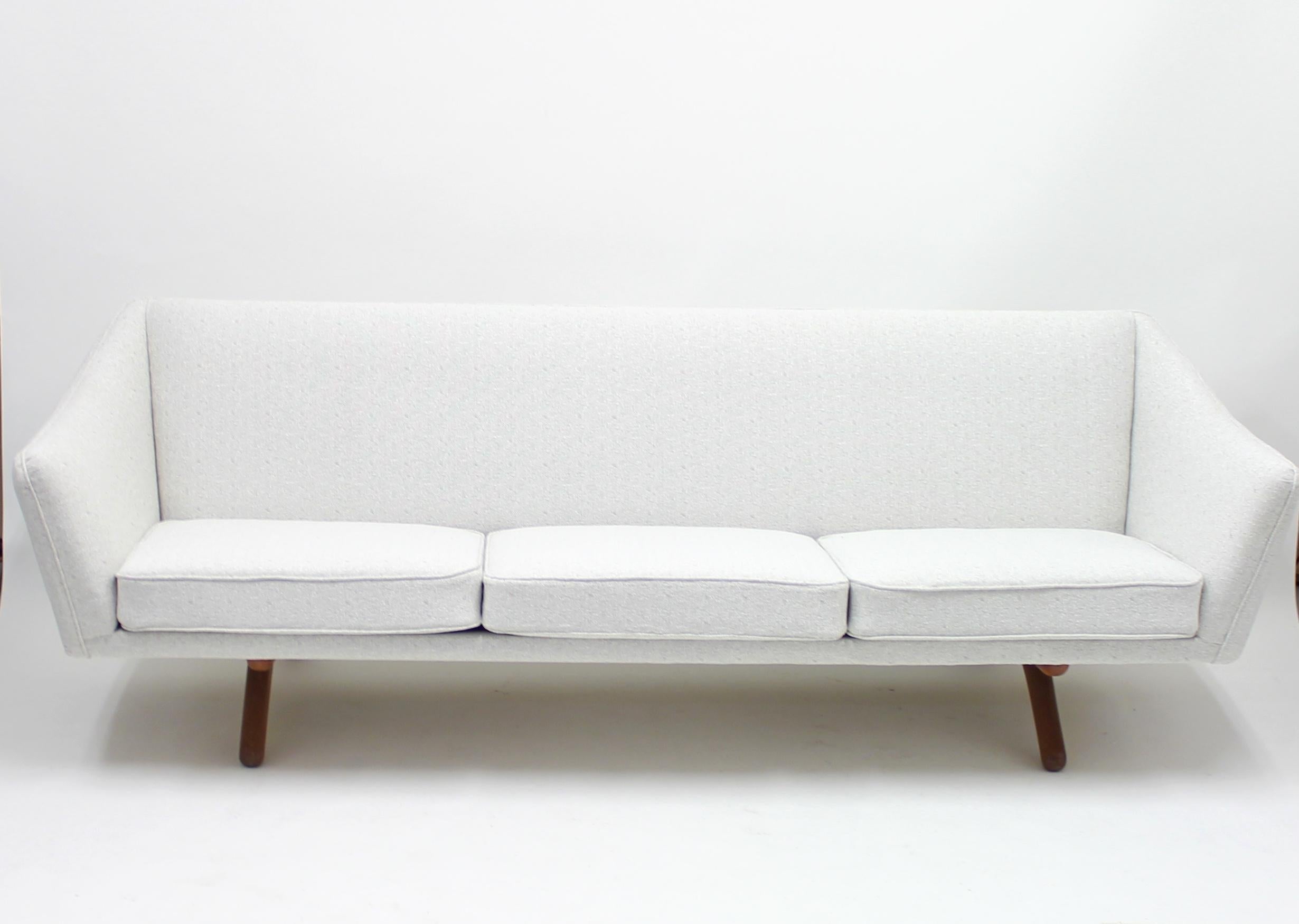 Three seater sofa, model ML-140, designed by Illum Wikkelsø for A/S Michael Laursen. An all Danish collaboration. Newly upholstered in an off-white fabric that sits on a teak base with A-shaped legs. Very good condition with minimal ware.