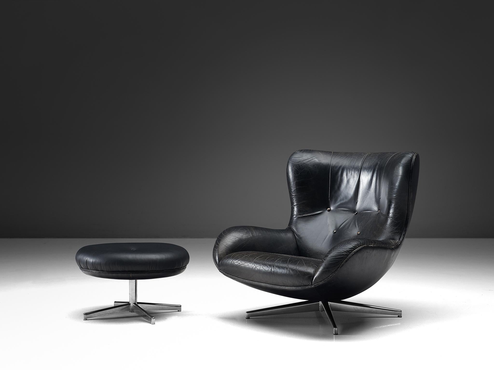 Illum Wikkelsø for A. Mikael Laursen, swivel lounge chair with ottoman model ML214, black leather and metal, Denmark, 1960s.

Organic shaped easy chair in patinated black leather by Danish designer Illum Wikkelsø. This swivel chair shows some nice