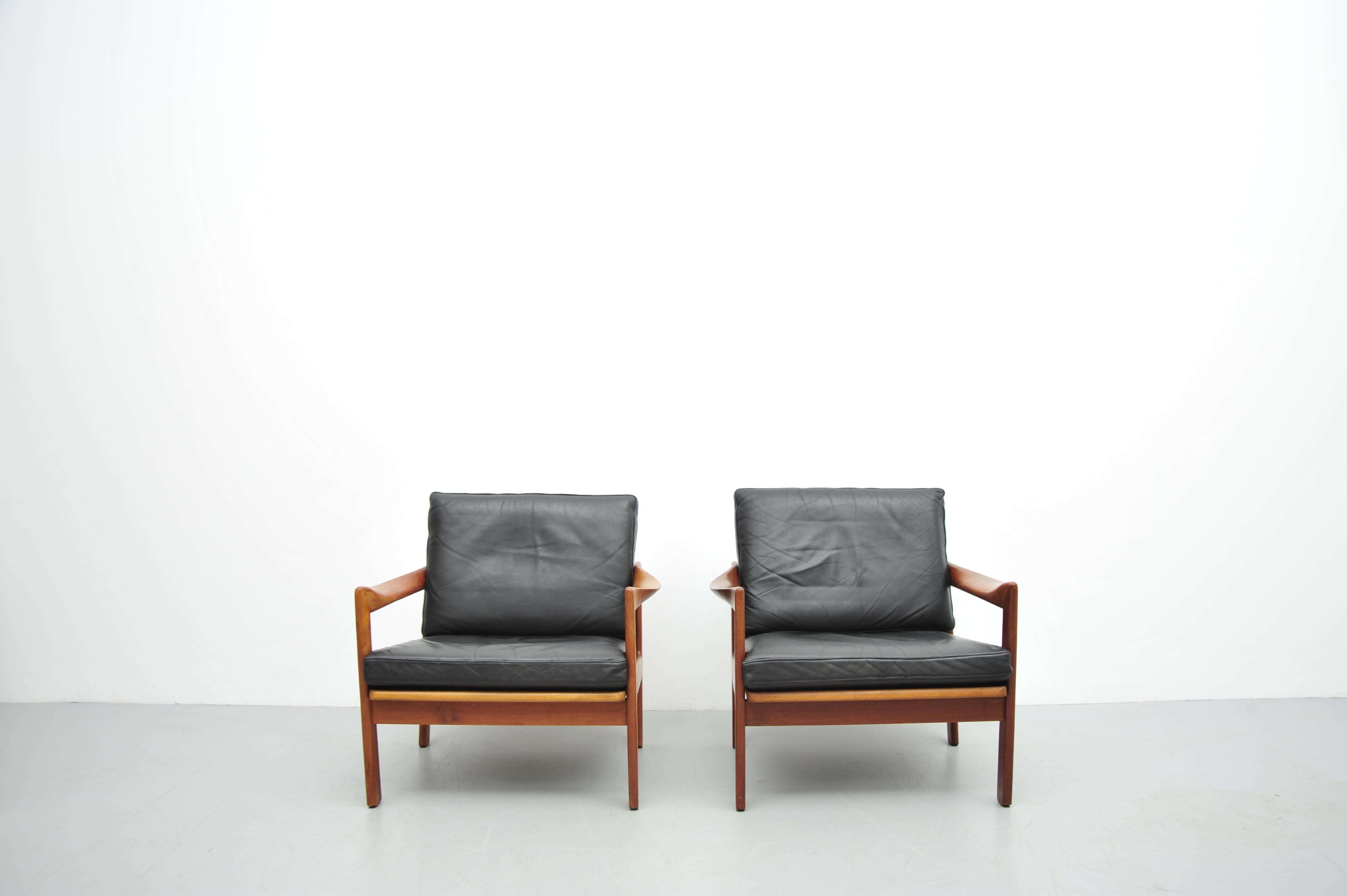 Este elegante 2er Set Vintage-Sessel fue diseñado por Illum Wikkelsø en los años 50 y fabricado por Niels Eilersen en Dinamarca. La combinación de madera de teca y fibra de vidrio en negro confiere a estas sillas su característico estilo de mediados