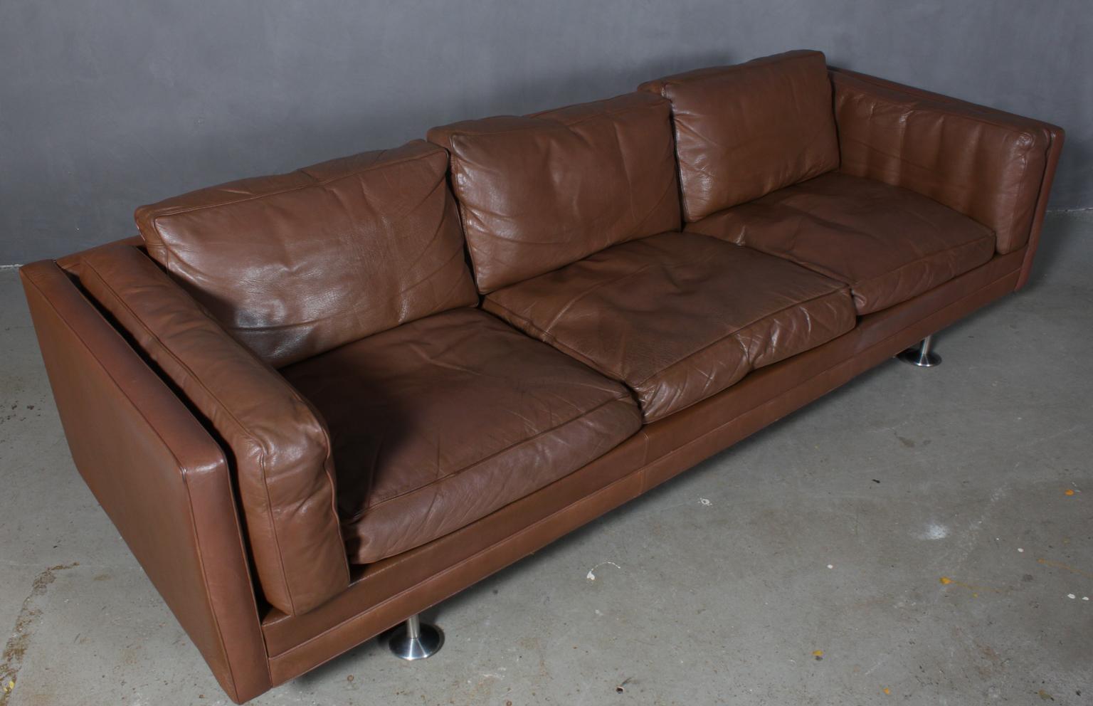 Illum Wikkelsø three-seat sofa original upholstered with patinated brown leather.

Legs of steel.

Made by Ryesberg Møbeler.