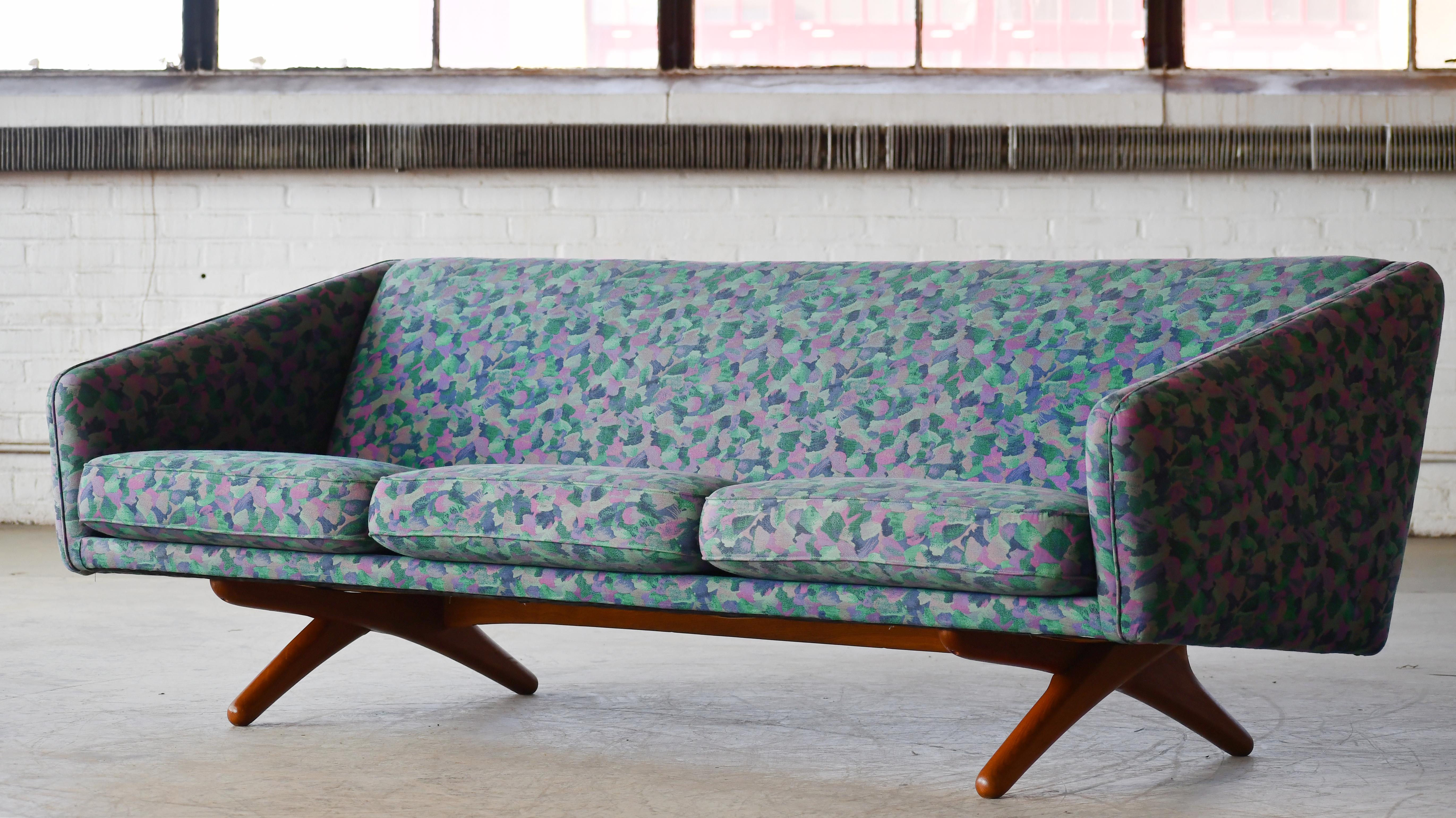 Beautiful Iconic Danish modern sofa by famed Illum Wikkelso. Clean functional and very modern lines with loose cushions raised on cross legs and frame of oak. Made in the second half of the 1960's. Reupholstered at a later point in a multicolored