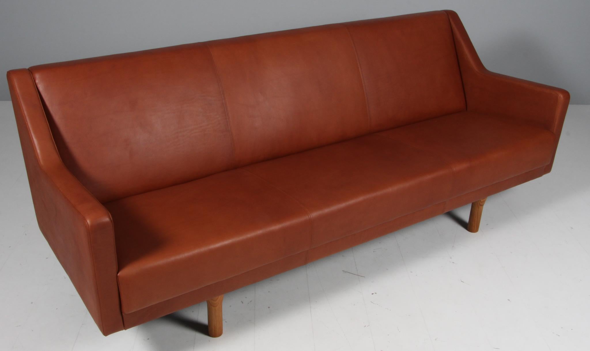 Illum Wikkelsø three seat sofa, new upholstered with tan full grain aniline leather. 

Tapered solid oak legs.

