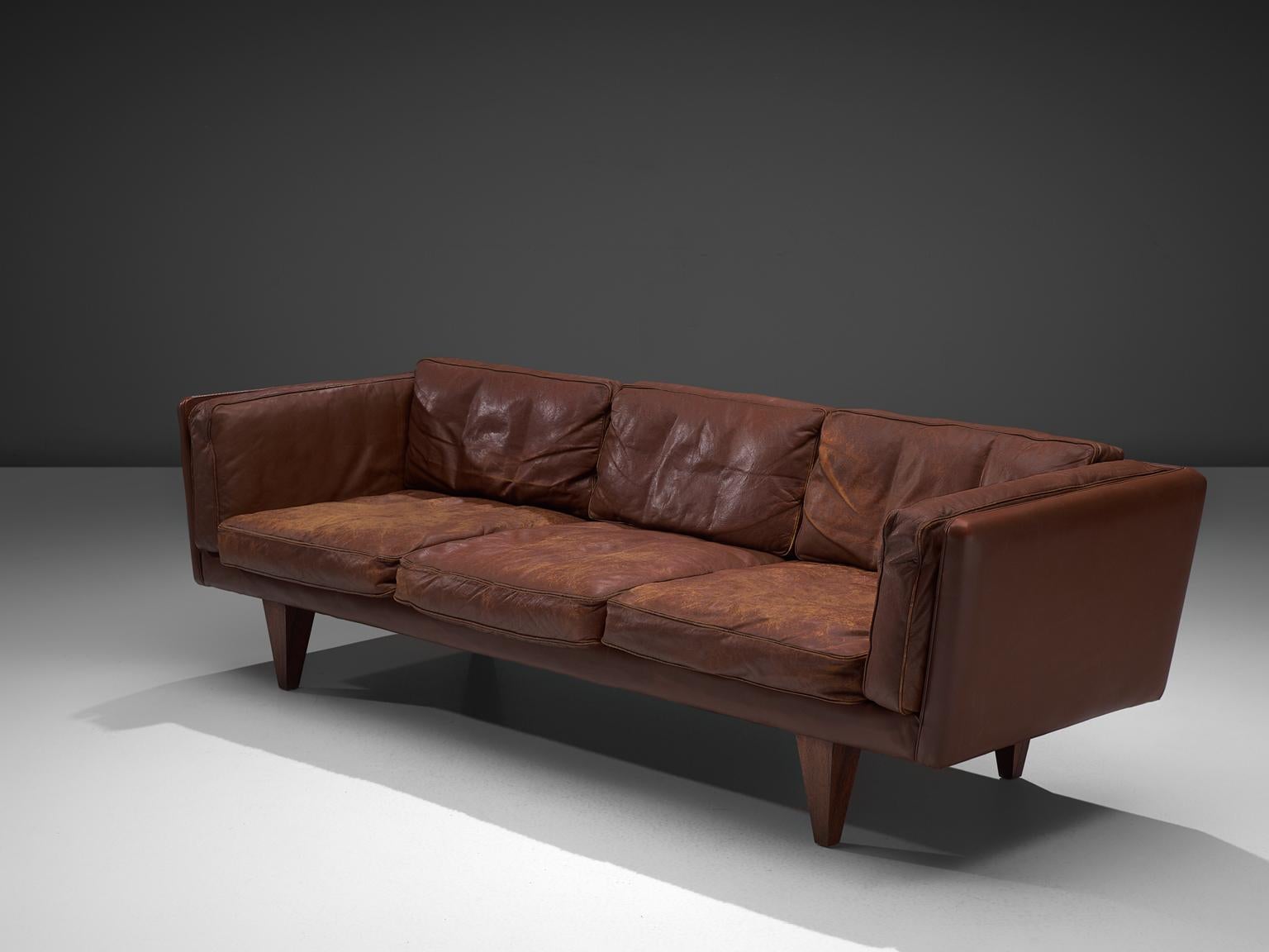 Illum Wikkelsø, sofa model V11, dark cognac leather and wood, Denmark, 1960s.

Stunningly three-seat sofa, designed by Danish designer Illum Wikkelsø. Highly comfortable and beautiful designed sofa with brown leather upholstery. The nonchalant and