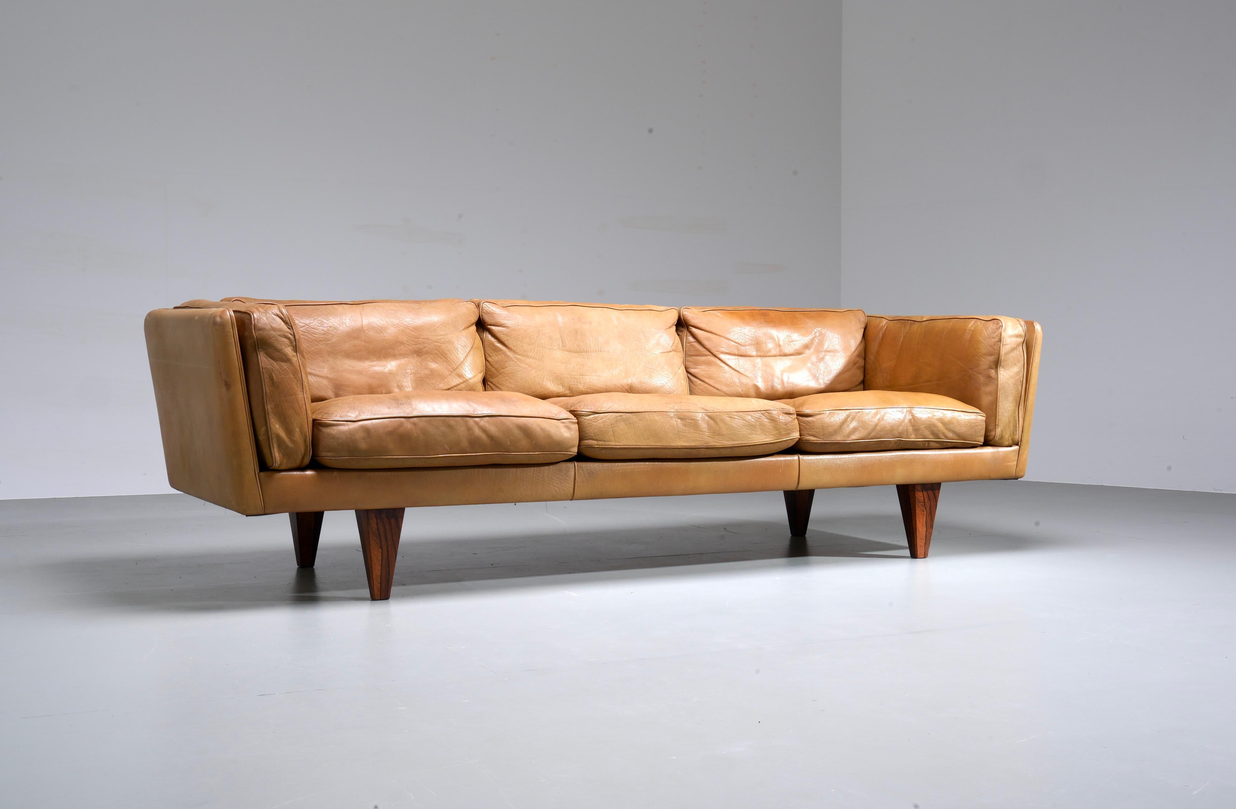 Illum Wikkelsø Three-seat ‘V11’ sofa in cognac coloured leather and wooden pyramid legs.

Perfect proportions is what makes this V11 sofa by Illum Wikkelsø so special. The leather runs all the way through, also at the back, making this sofa a