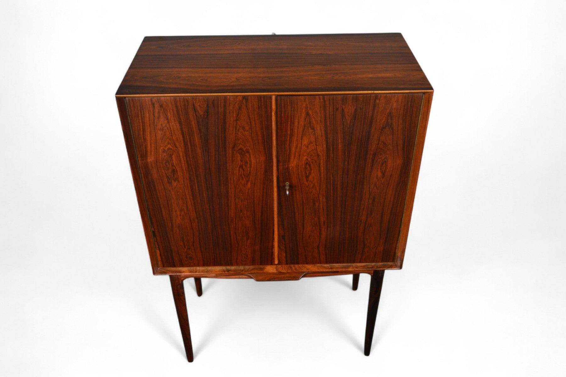 Origine: Danimarca
Designer: Illum Wikkelsø
Produttore: A.I.C.
Epoca: anni '60
Materiali: Palissandro
Misure: 31,5″ di larghezza x 16,5″ di profondità x 45″ di altezza