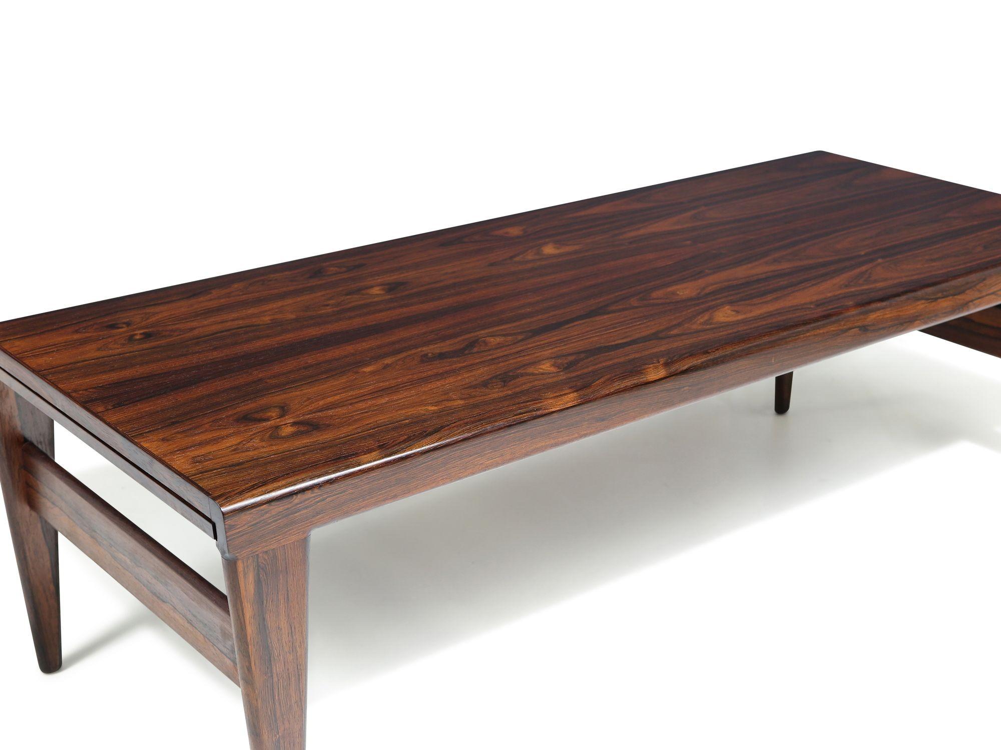 Superbe table basse en palissandre brésilien du milieu du siècle, conçue par Illum Wikkelso, Danemark. La table basse présente une menuiserie fine et un palissandre brésilien magnifiquement grainé avec des motifs de grain dynamiques et des veines