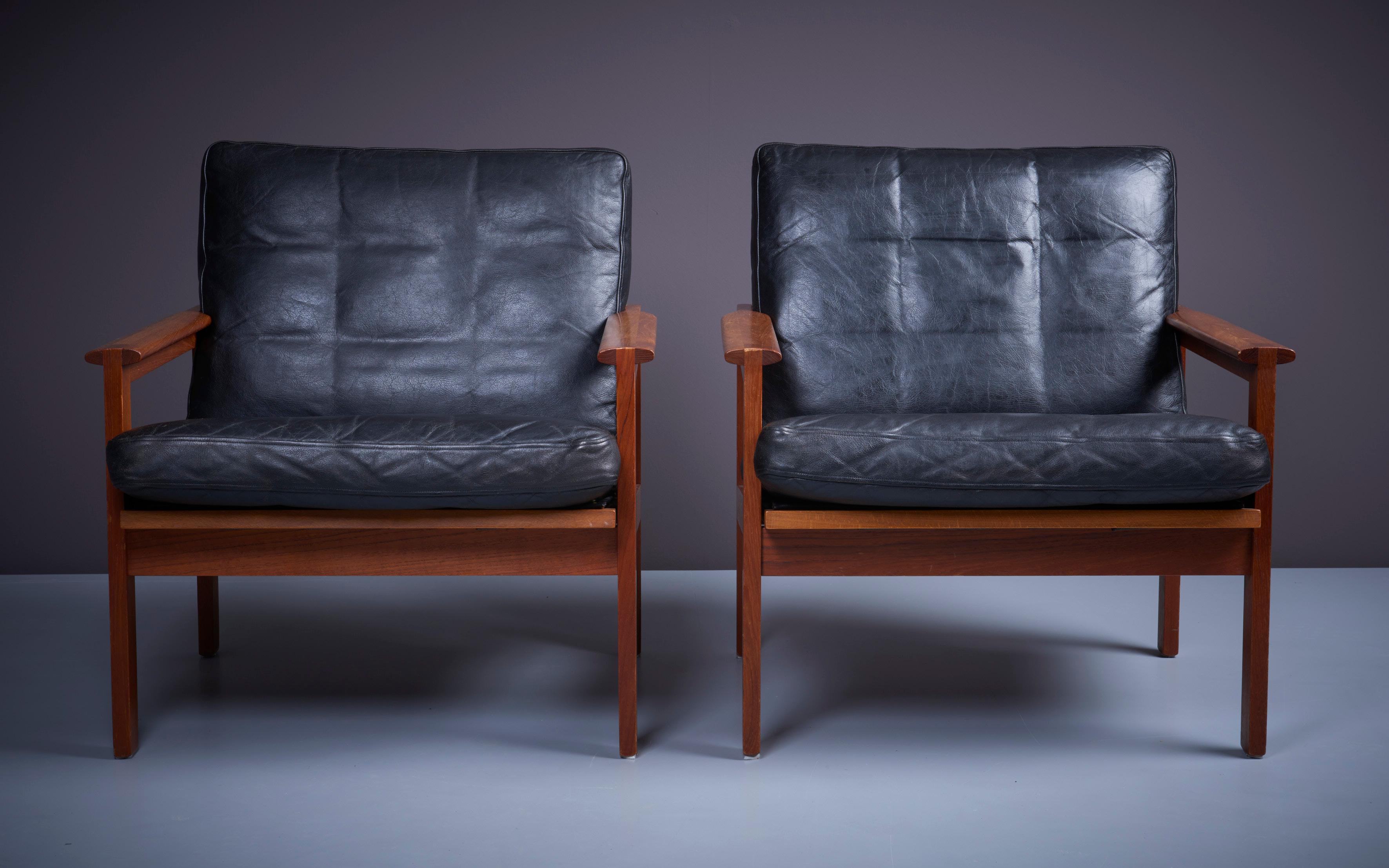 Original condition 'Capella' set of 2 armchairs by Danish furniture designer Kristian Illum Wikkelsø (1919-1999) for Niels Eilersen. Outstanding quality with solid teak frames and beautiful black leather seat and cushions in original condition. We