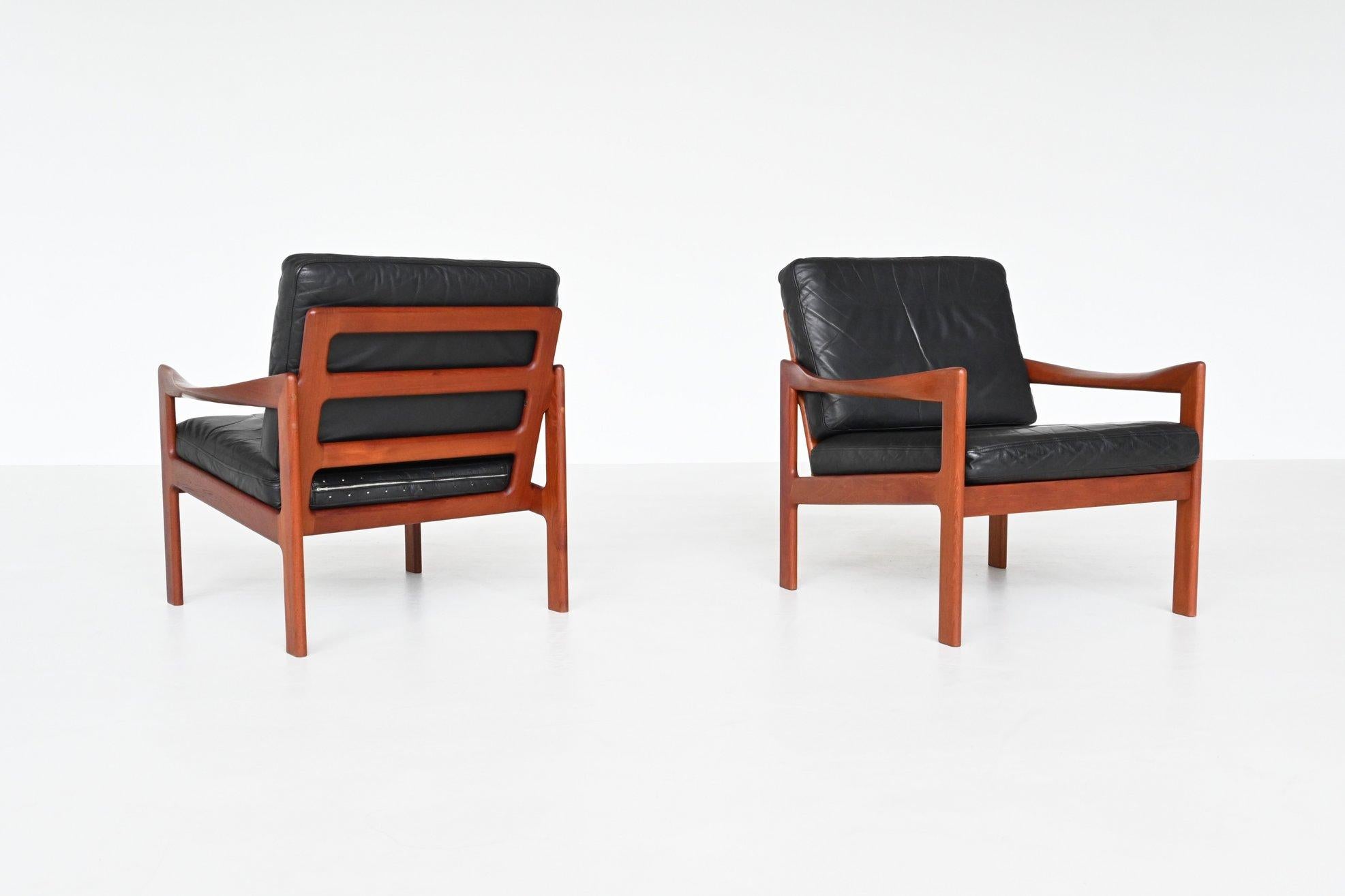 Beautiful elegant shaped pair of lounge chairs designed by Illum Wikkelsø and manufactured by Niels Eilersen, Denmark 1962. These sculpted low back chairs feature a solid teak wooden frame and the cushions are upholstered with original black