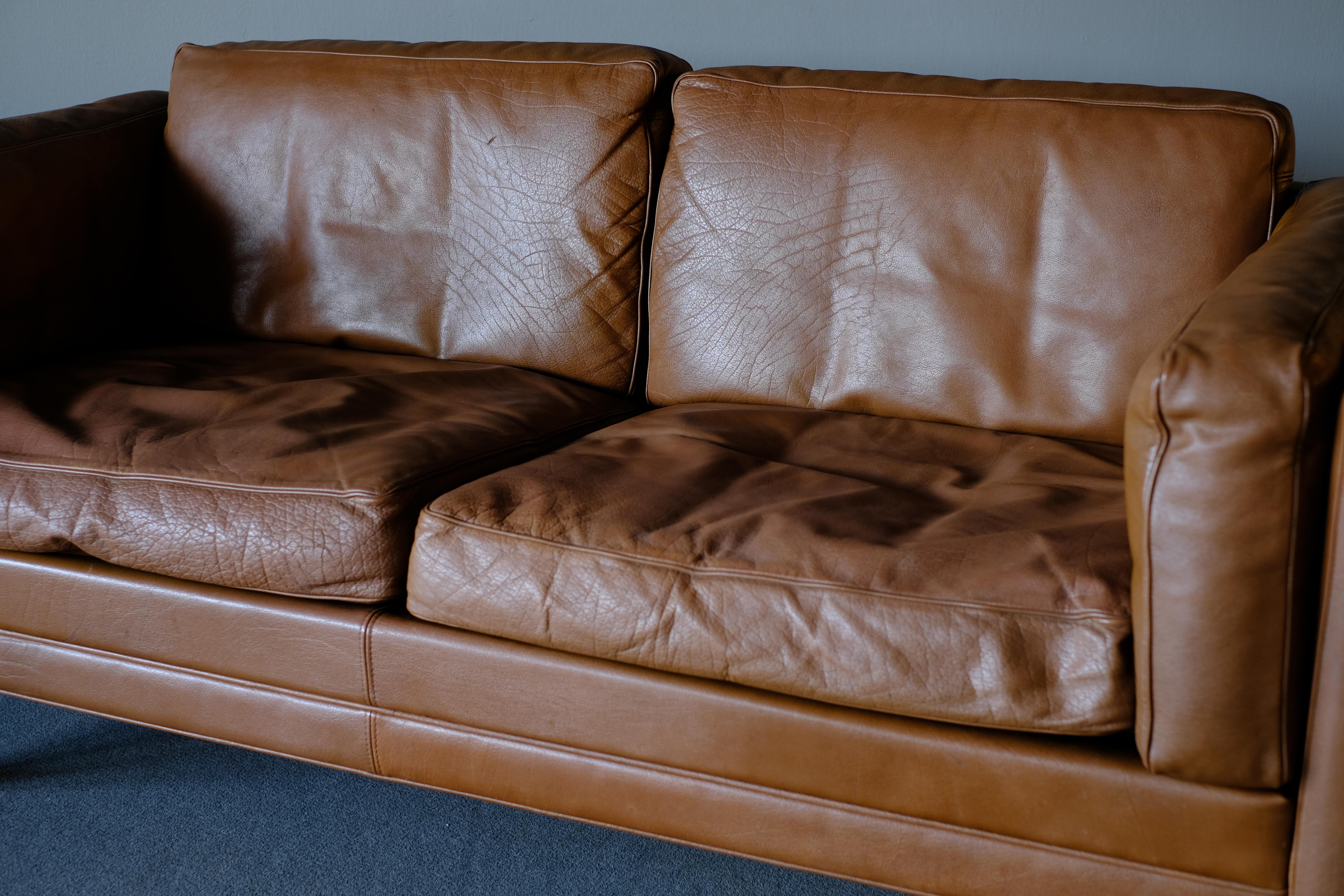 Wonderful 2-seat sofa, model V11 upholstered in brown leather designed by Illum Wikkelso for Holgar Christiansen in 1960s-1970s. This sofa comes with its fully original upholstery of high quality brown leather in all its patinated glory. The tapered