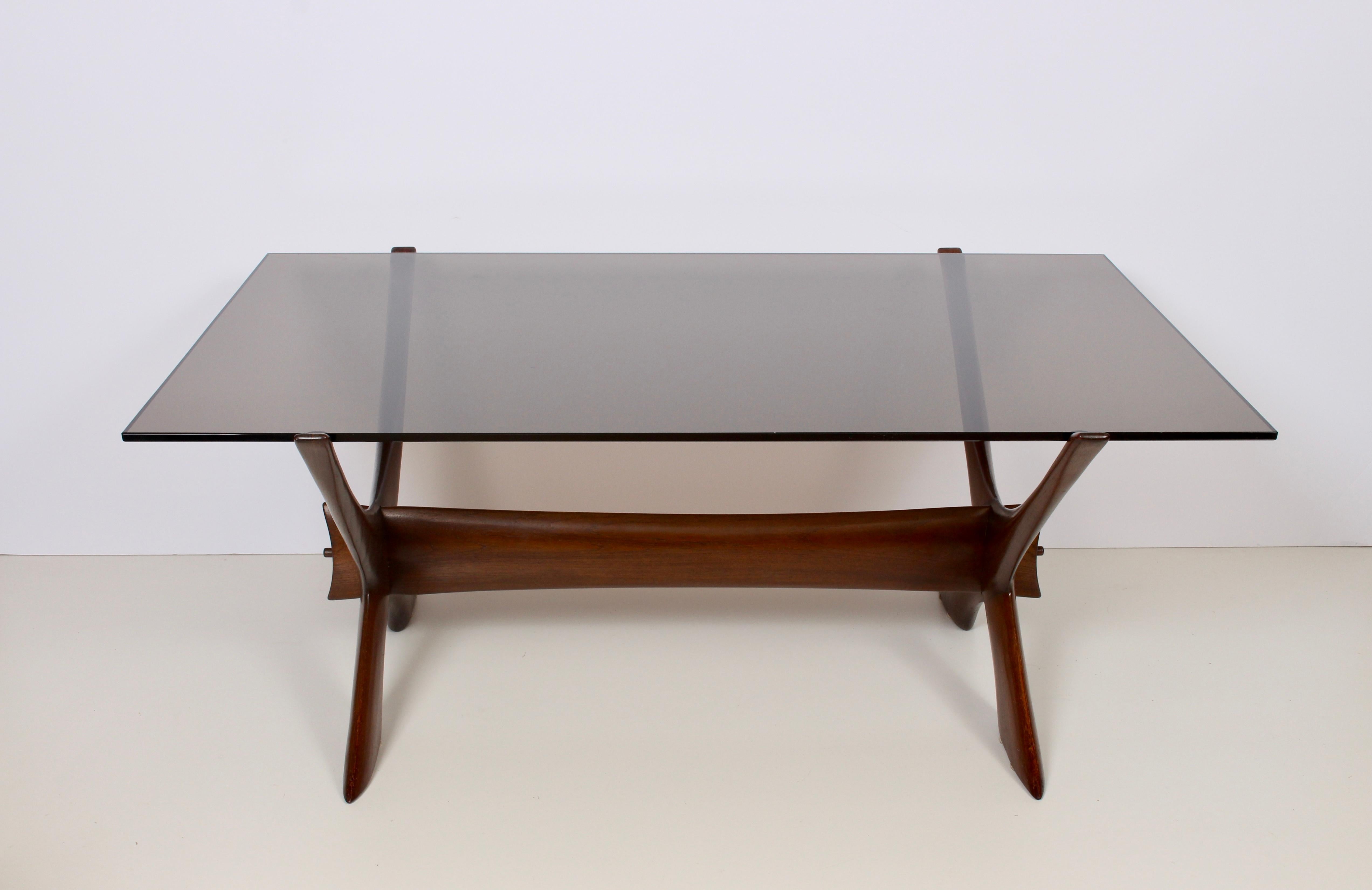 Danish Modern Illum Wikkelso for C. F. Christensen teak coffee table with smoked gray glass surface. Featuring a smooth, braced and sturdy rectangular, dark teak x framework with (34D x 53W) smoky grey glass surface. Timeless. Sculptural. Fine