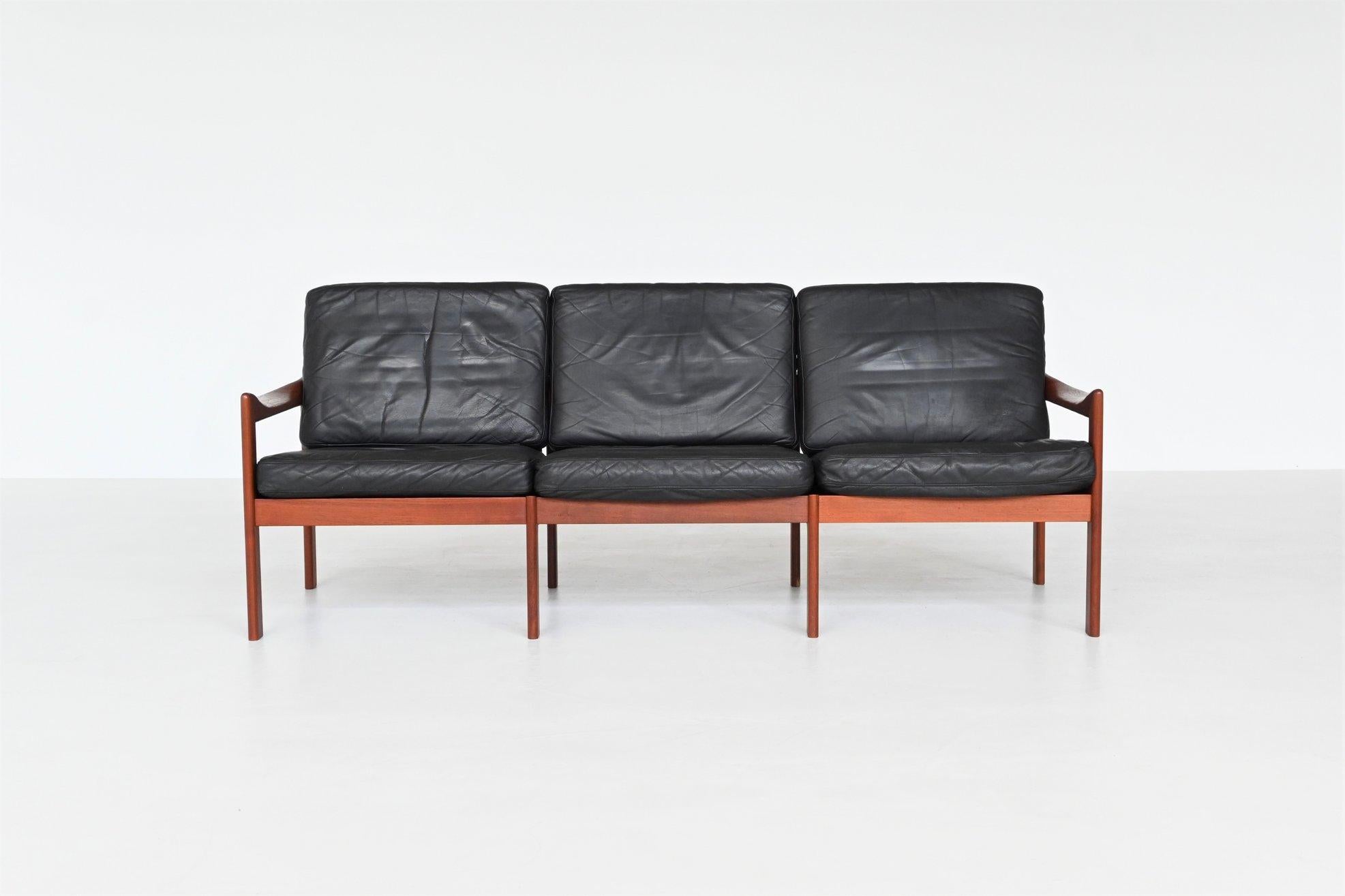 Beautiful elegant shaped three-seat sofa designed by Illum Wikkelsø and manufactured by Niels Eilersen, 1962. This sculpted sofa features a solid teak wooden frame and the cushions are upholstered with original black leather. Some beautiful details