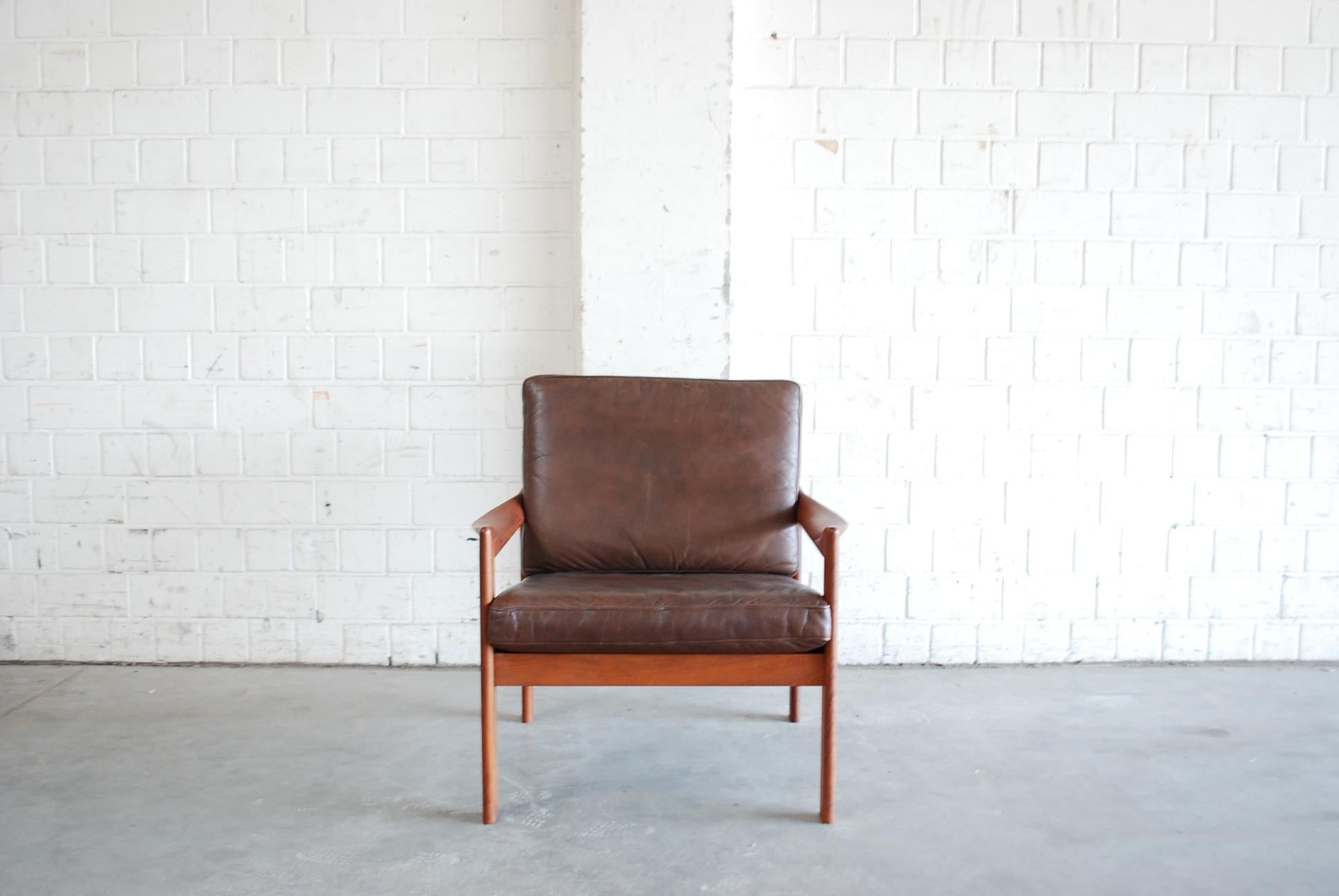 Chaise moderne danoise en teck avec cuir aniline marron.
Conçu par Illum Wikkelsø et fabriqué par Niels Eilersen.
Grand confort grâce aux accoudoirs organiques incurvés.