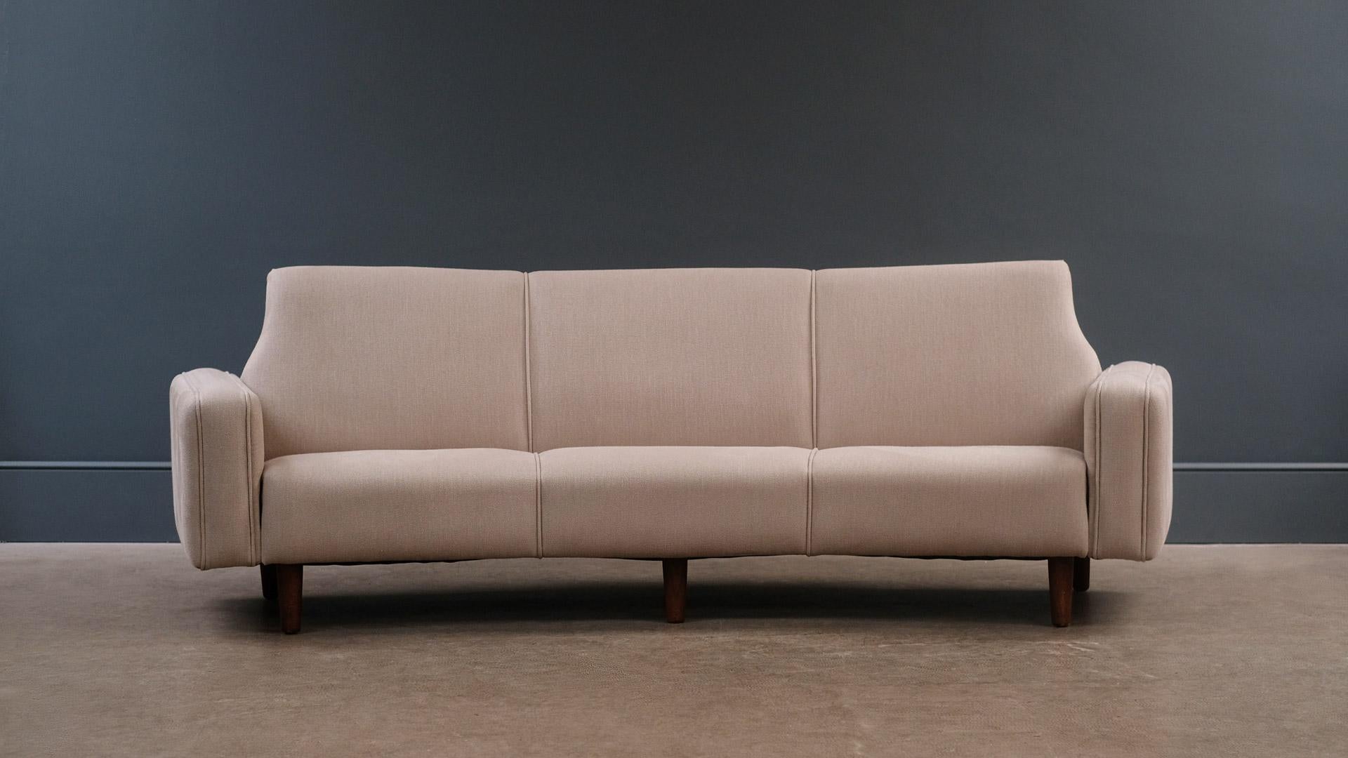 A rare and beautiful curved sofa designed by Illum Wikkeslo for Aarhus Mobelfabrik, Denmark, 1958. This example fully refurbished and reupholstered in heavy linen fabric by Kirkby.