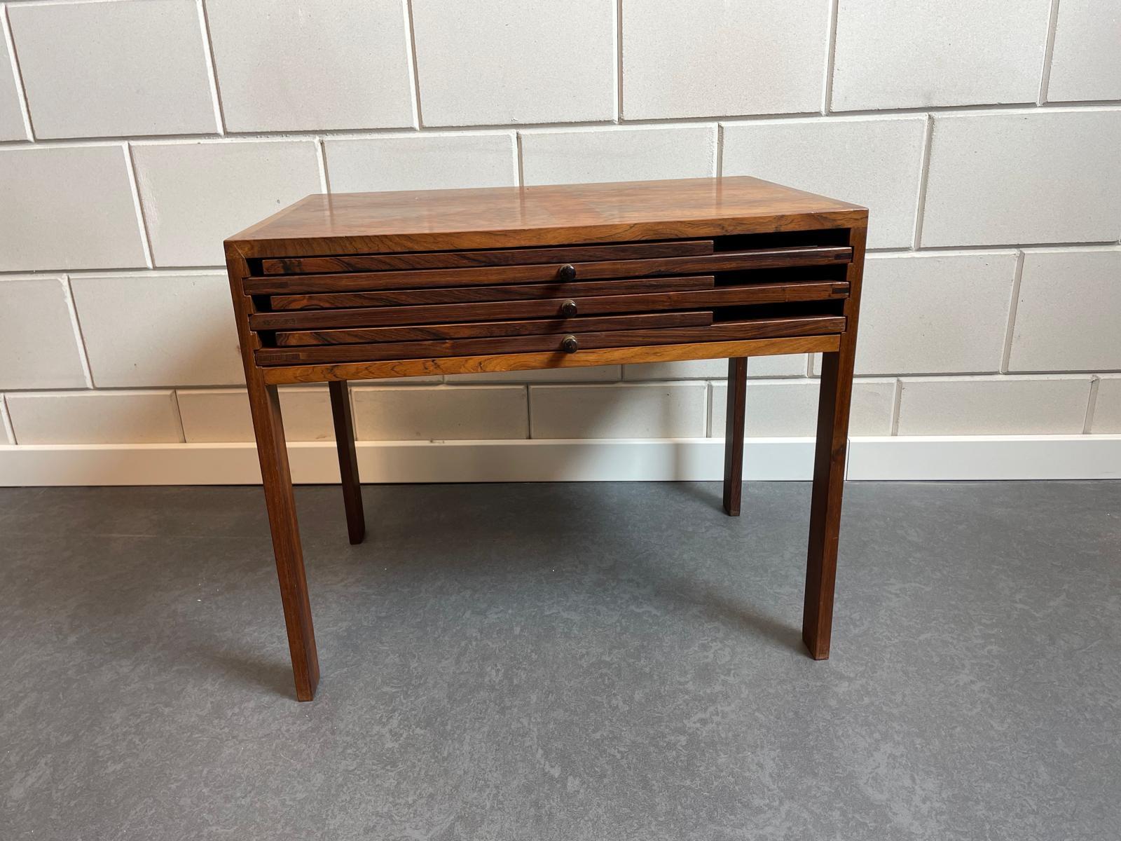 Illum Wikkelsø is the Danish designer of this unique set of nesting tables.
It is the complete and original set of three folding tables . Three tables that nest into an occasional table. The manufacturer’s label is at the bottom CFC Silkeborg Made