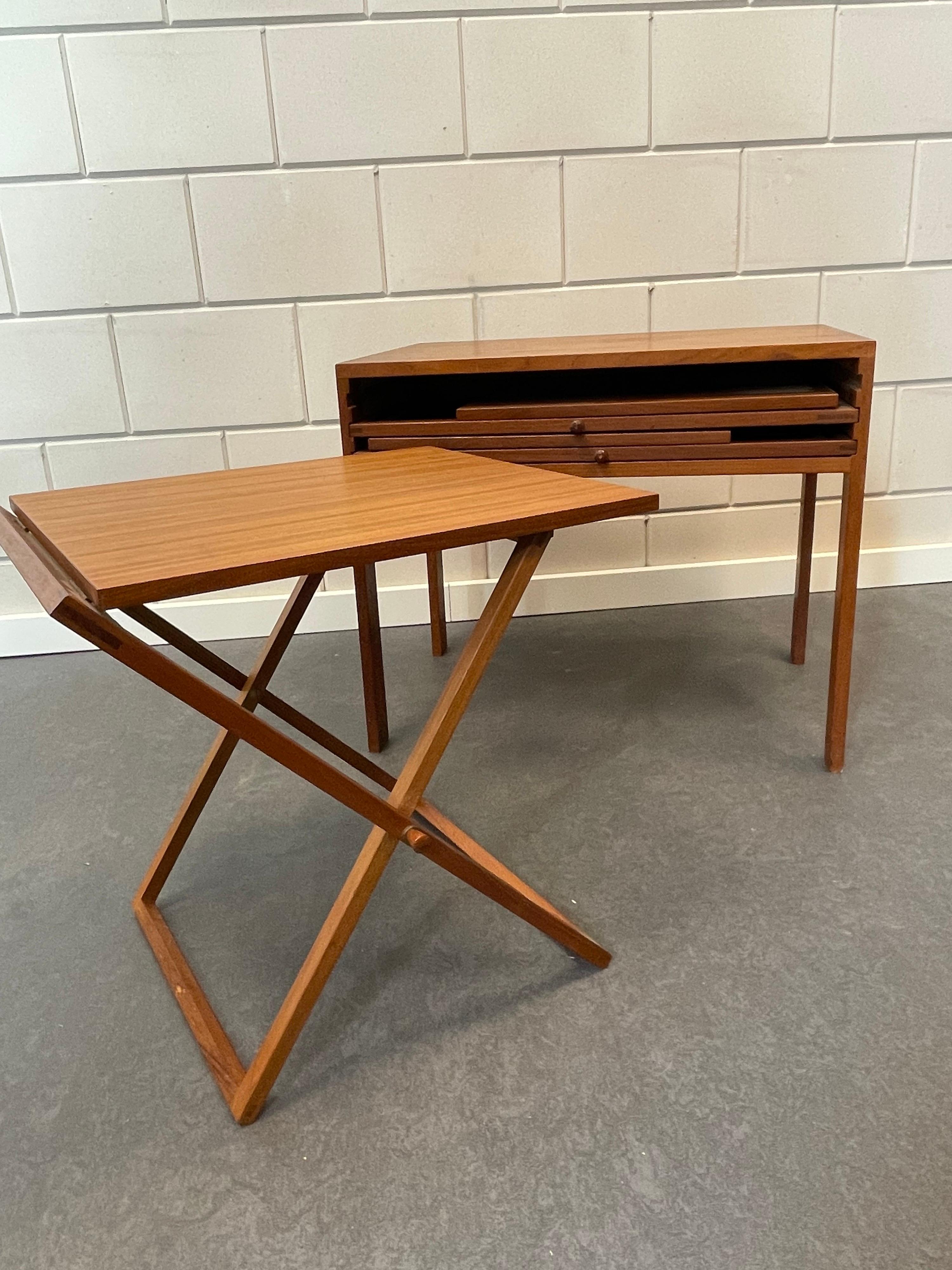 Illum Wikkelsø is the Danish designer of this unique set of nesting tables.
It is the complete and original set of three folding tables in teak. Three tables that nest into an occasional table. The manufacturer’s label is at the bottom CFC