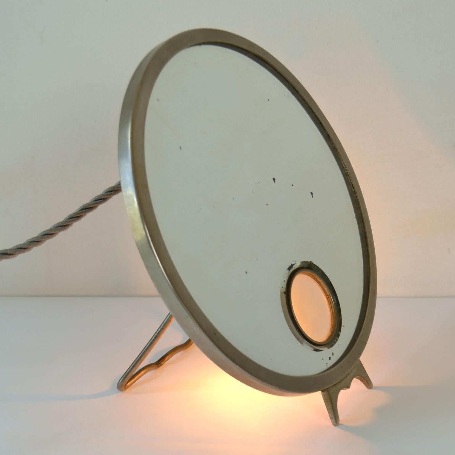 Der verstellbare Waschtischspiegel Brot Mirophar mit vernickeltem Rahmen und beleuchtetem Glas wurde 1927 entworfen. Die Innovation des Brot war das Konzept eines beleuchteten Vergrößerungsspiegels mit Opalglas. Sie wurden entwickelt, um das
