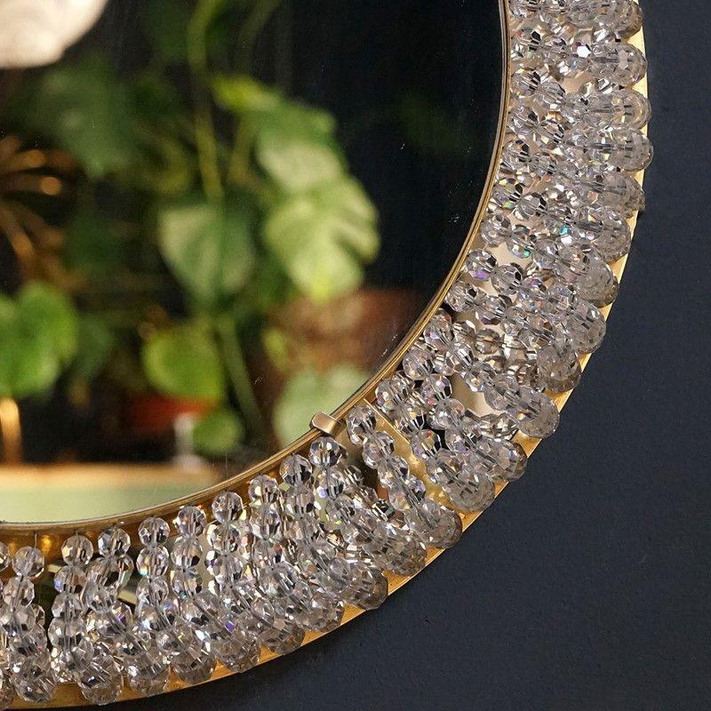 Mid Century Backlit Wall Mirror

Circular mirror framed by countless small faceted crystal beads which when illuminated gives off a warm glow.

Unsigned but very much in the style of Palwa.

Looks equally good turned off or on.

It is in excellent
