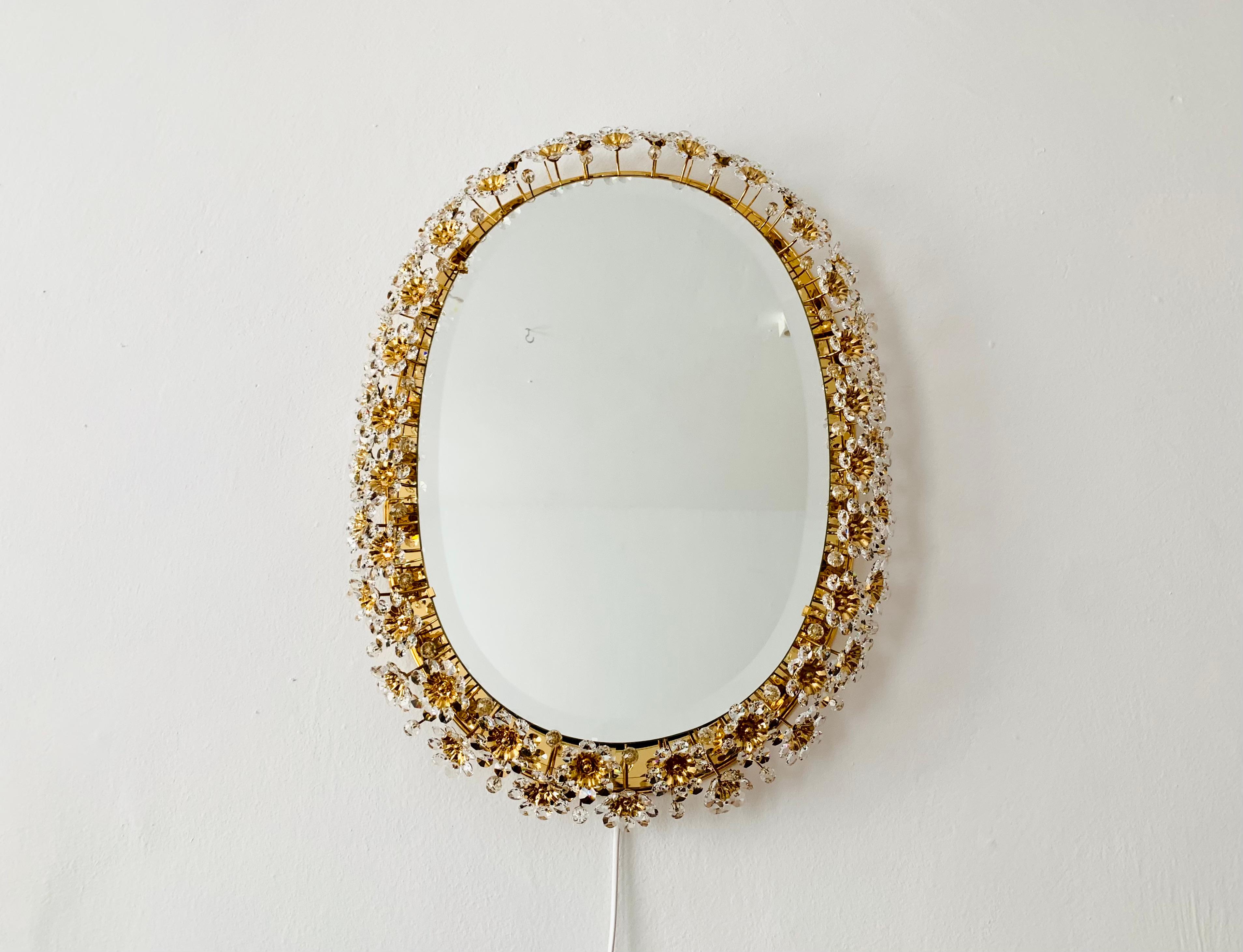 Wonderful and very luxurious mirror by Palwa from the 1960s.
The frame with the lavishly decorated crystal glass flowers sparkles particularly beautifully.
A stunning mirror and a real addition to any home.
A spectacular play of light is created in
