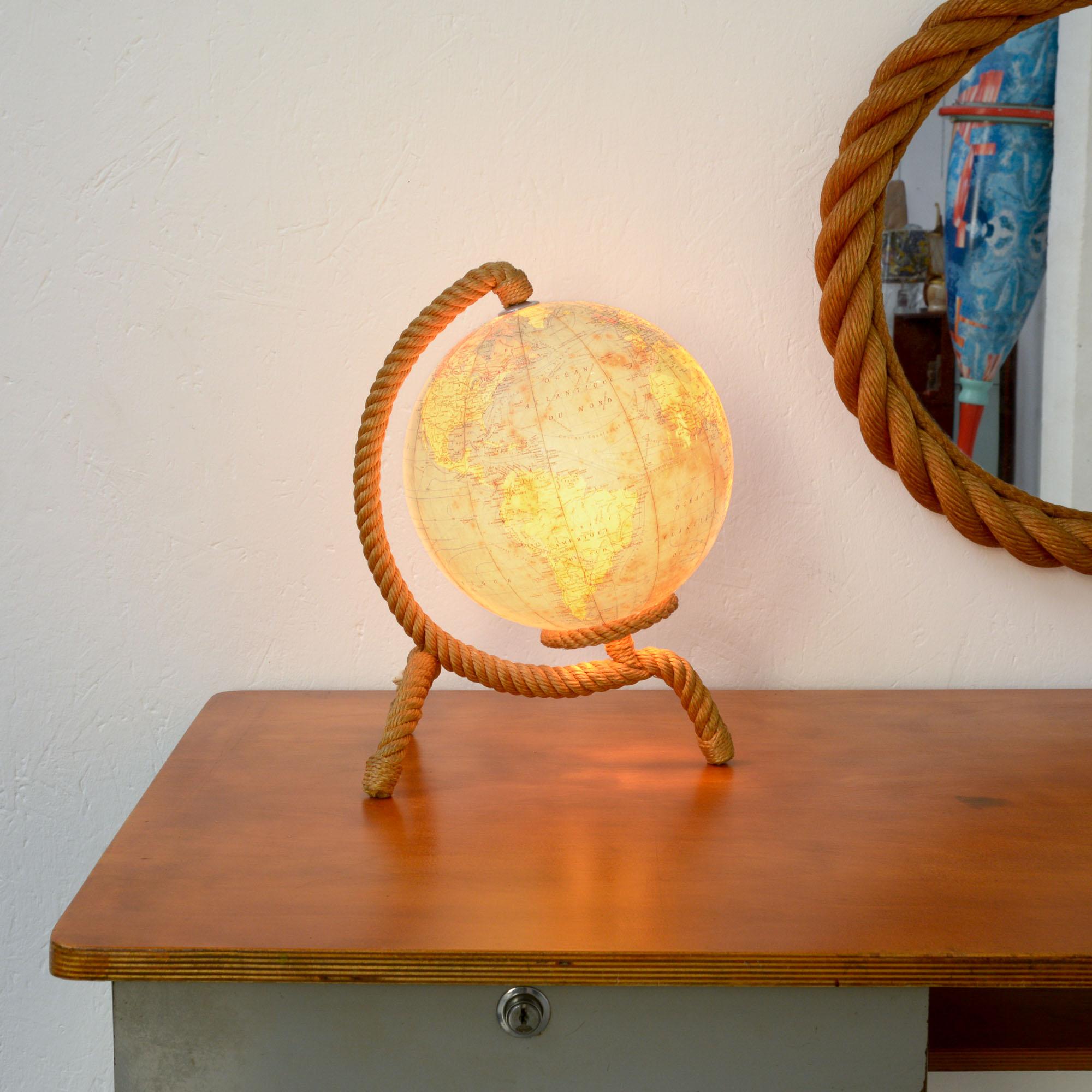 This illuminated globe was designed by Adrien Audoux et Frida Minet and manufactured by Cartes Taride in Paris.
This French couple of modernist designers has been very productive during the 1940s-1950s. The rope is used as leitmotiv in their