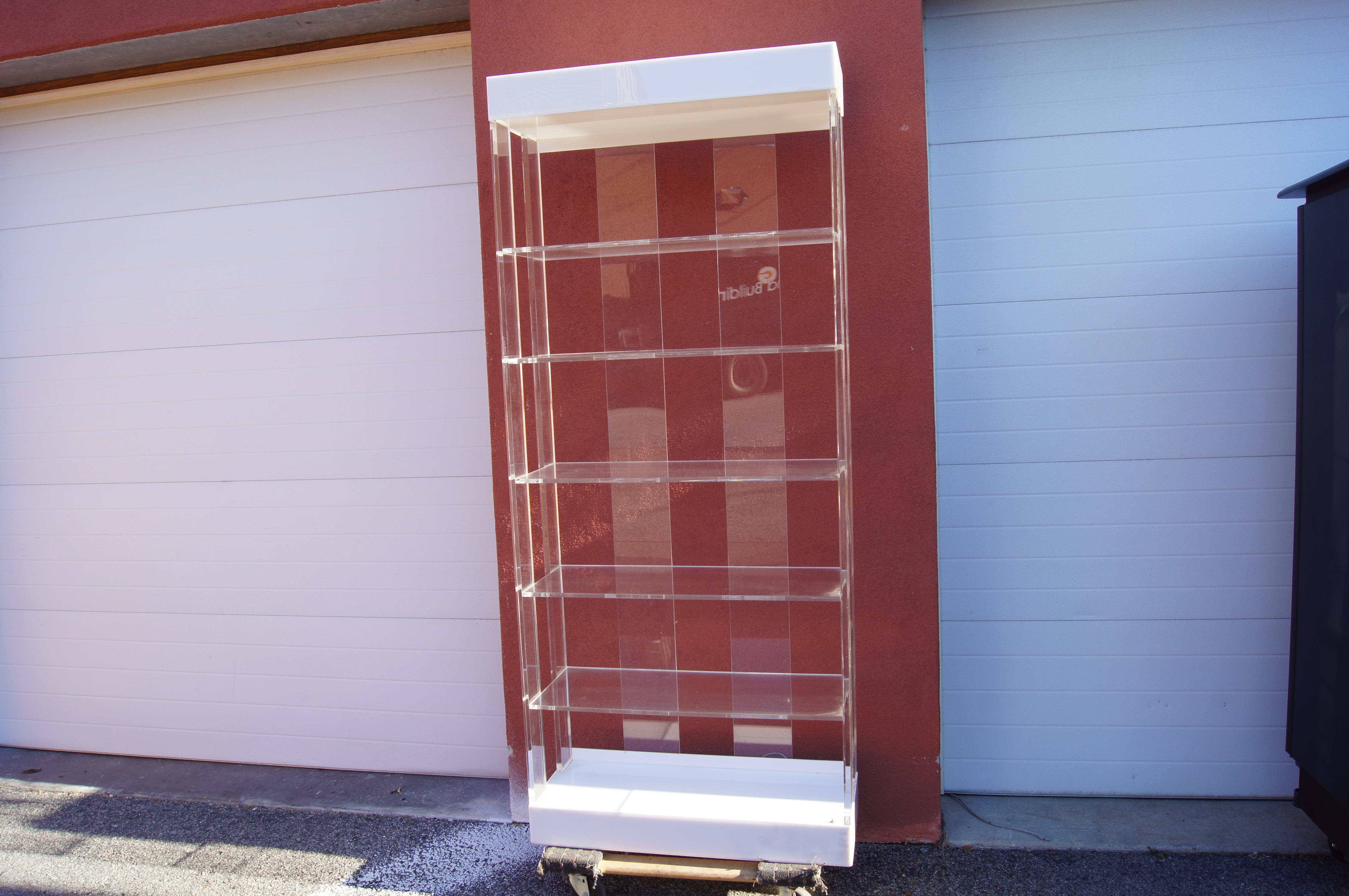 This sleek 1970s etagère by Pace Collection places five Lucite shelves between Lucite supports. The white acrylic base and top are illuminated for eye-catching displays. 

Two etagères are available.